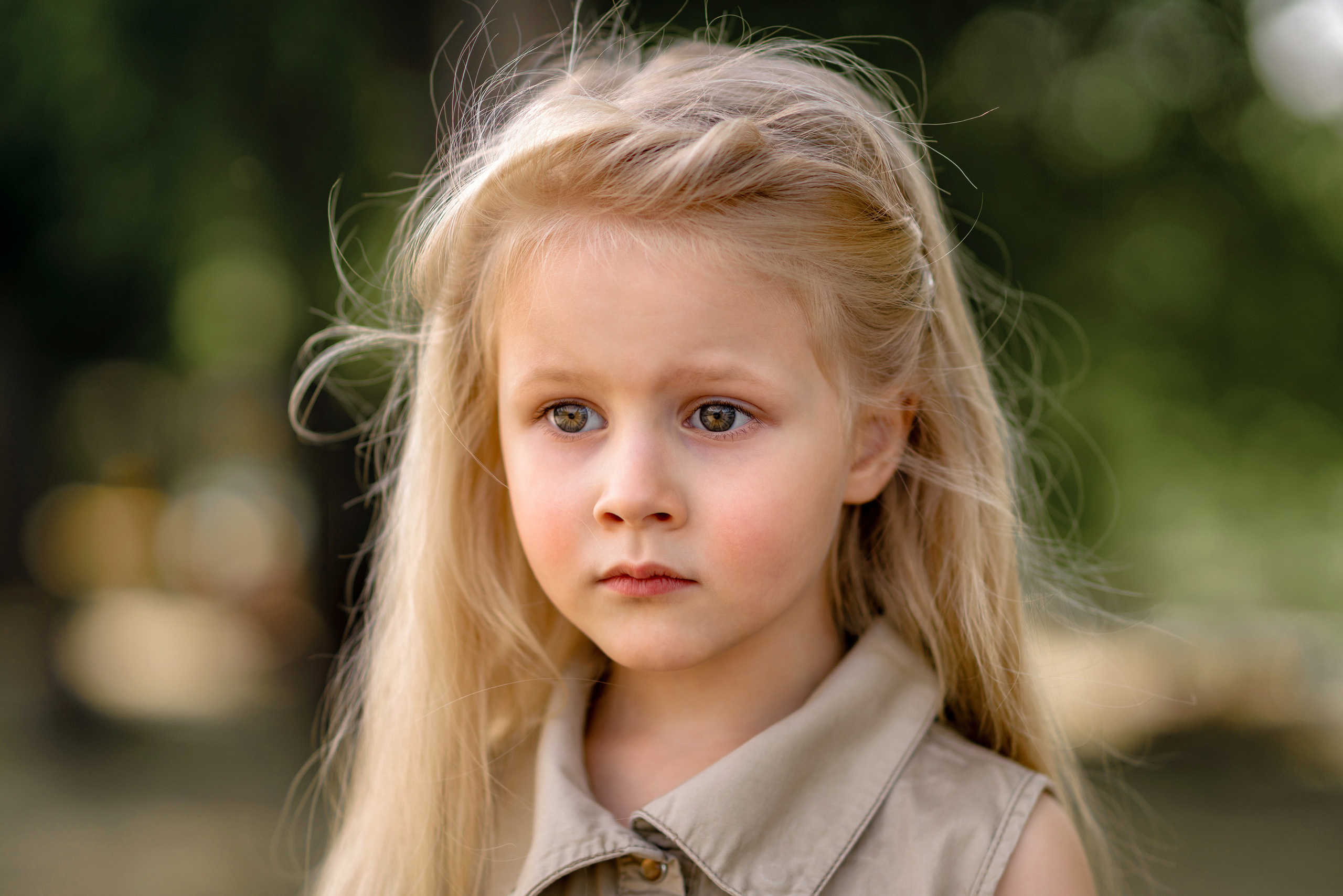 Крупный портрет грустной, светловолосой девочки