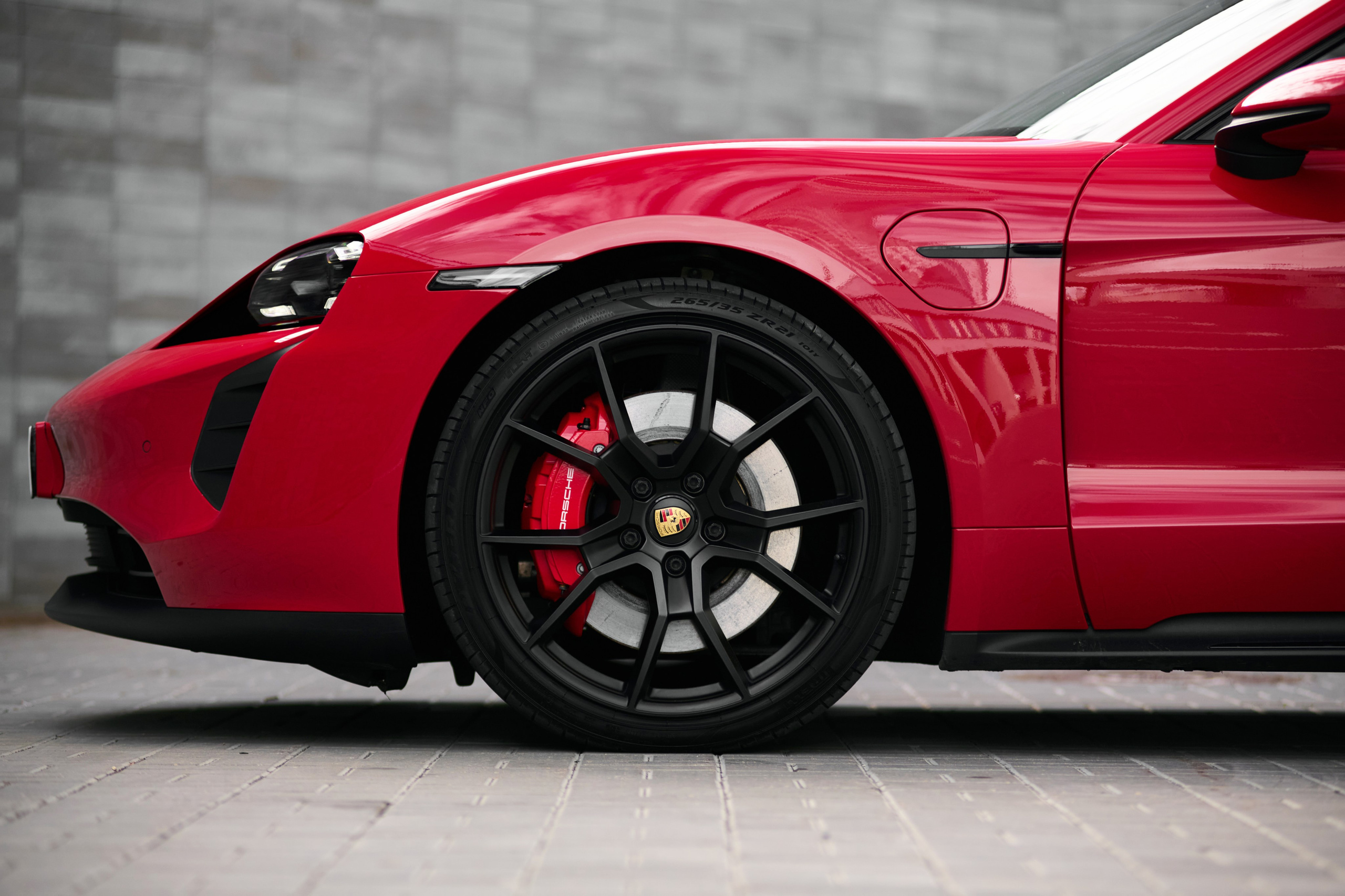 Переднее колесо и боковая часть красного Porsche Taycan GTS
