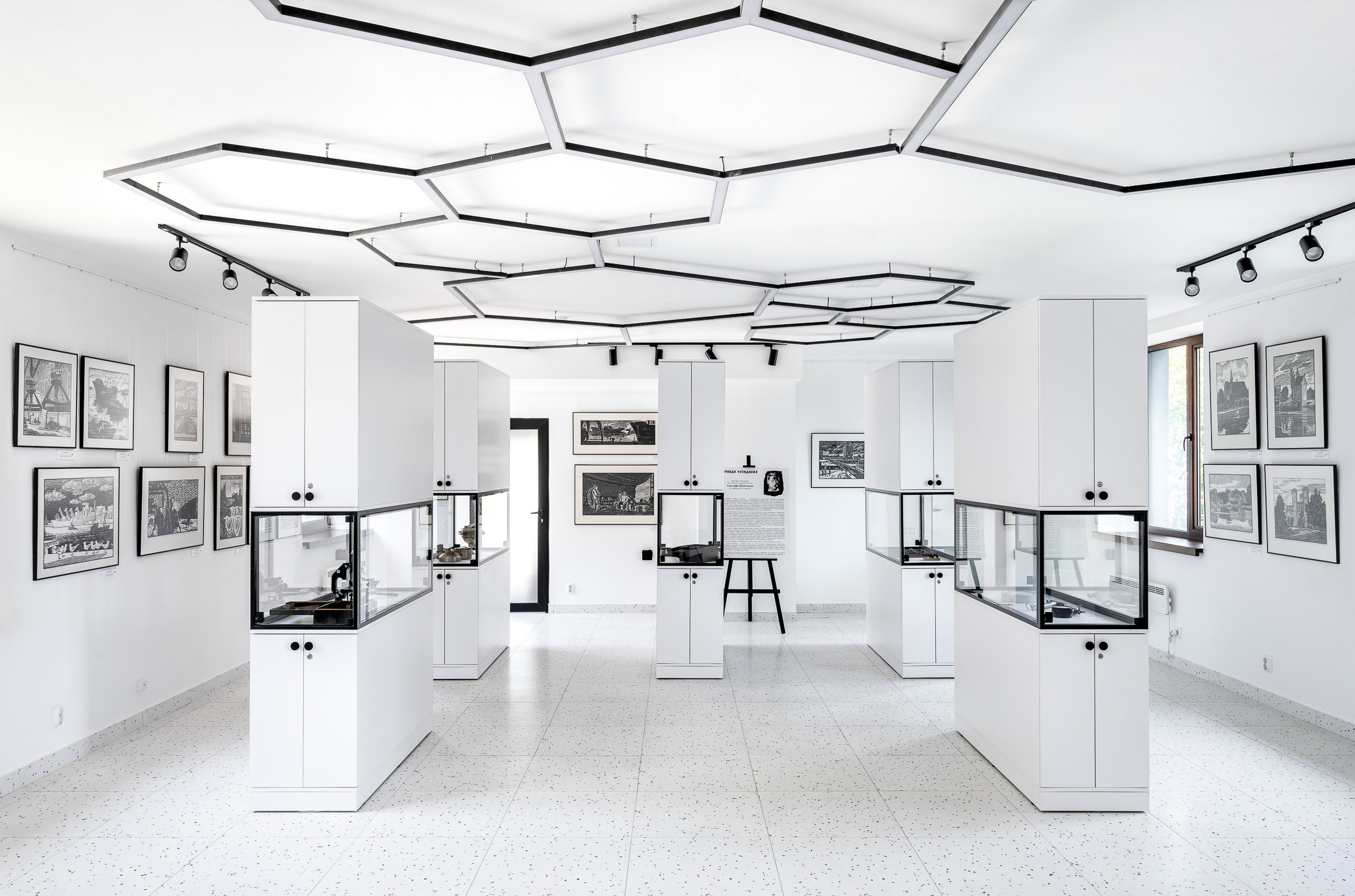 Галерея в белом цвете с выставочными шкафами.