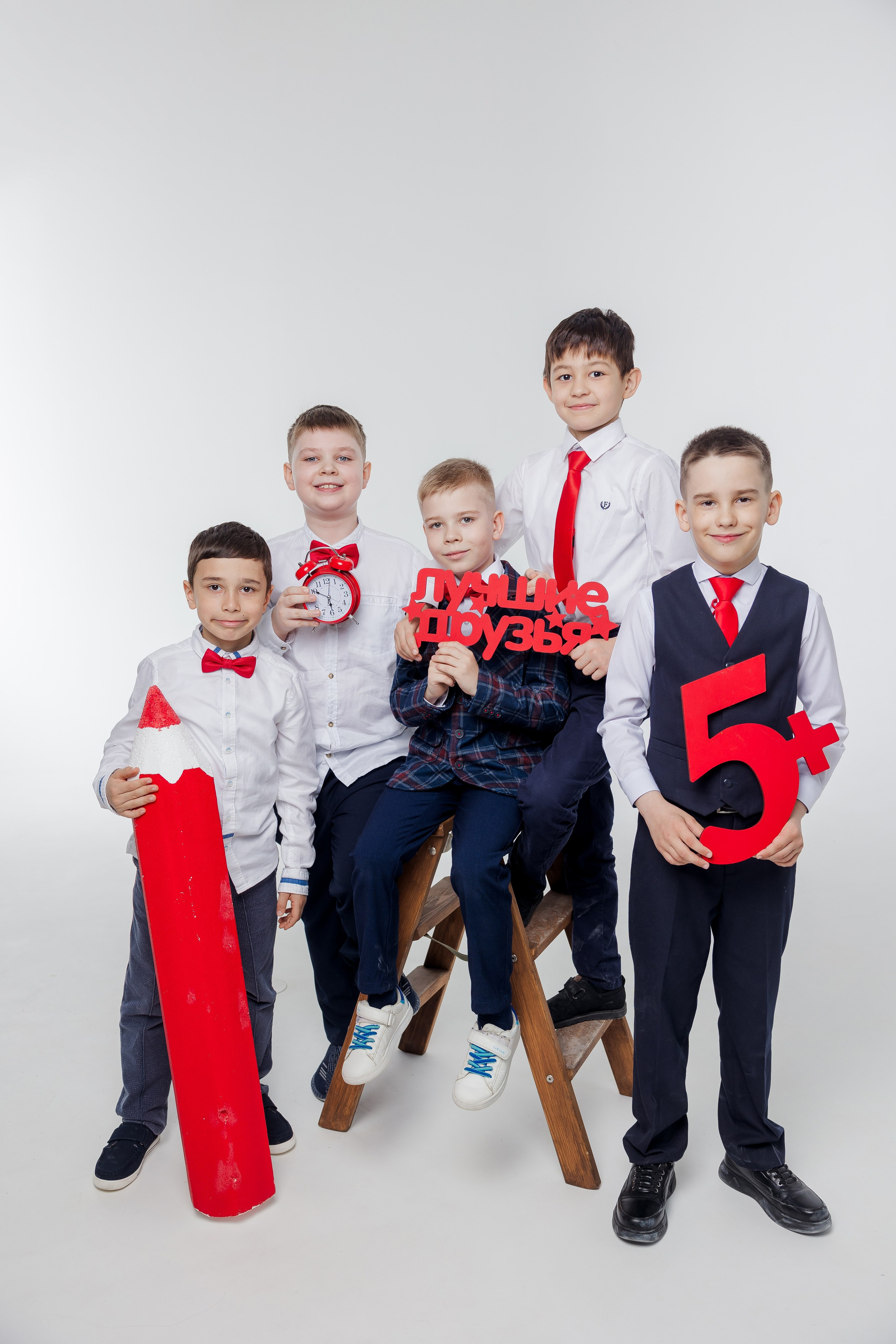 Группа мальчиков стоит вместе в студии с красным карандашом и надписью лучшие друзья