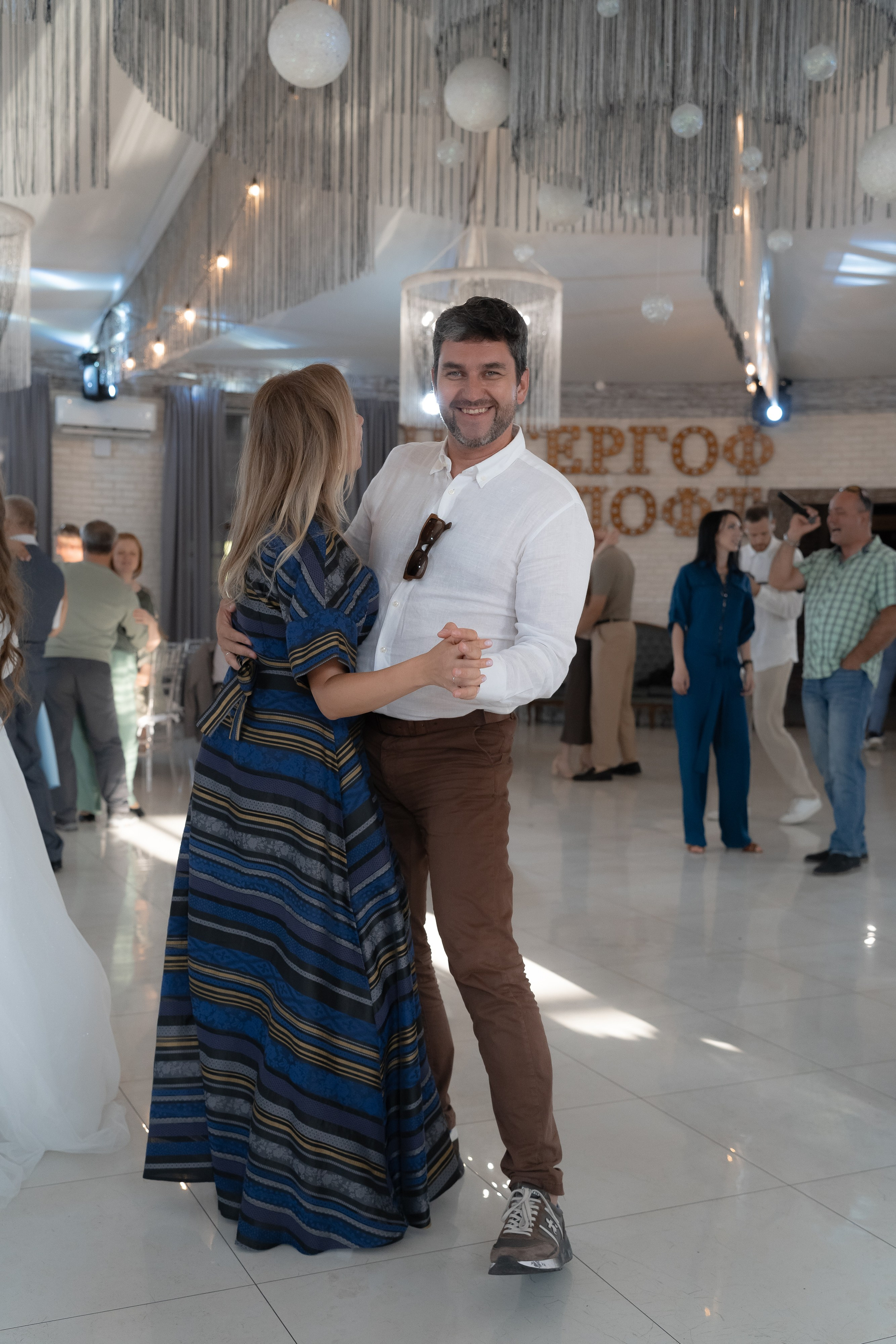 Танец пары под тёплым светом гирлянд на свадьбе в Петергоф Лофт