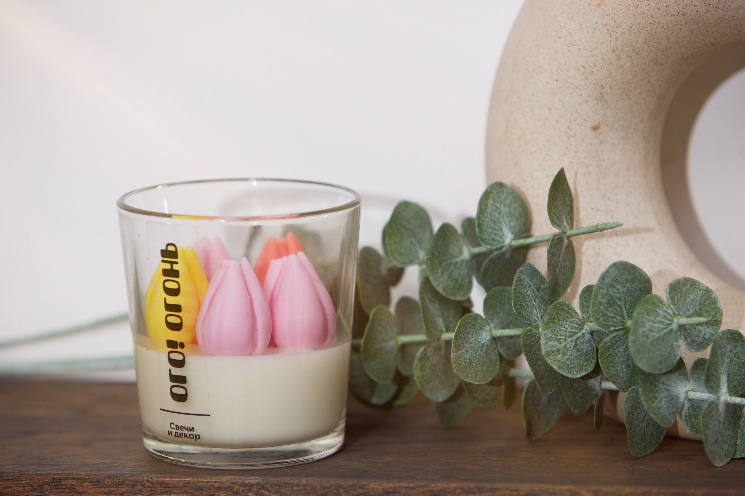 Свеча в прозрачном стакане с лепестками — предметная съёмка.