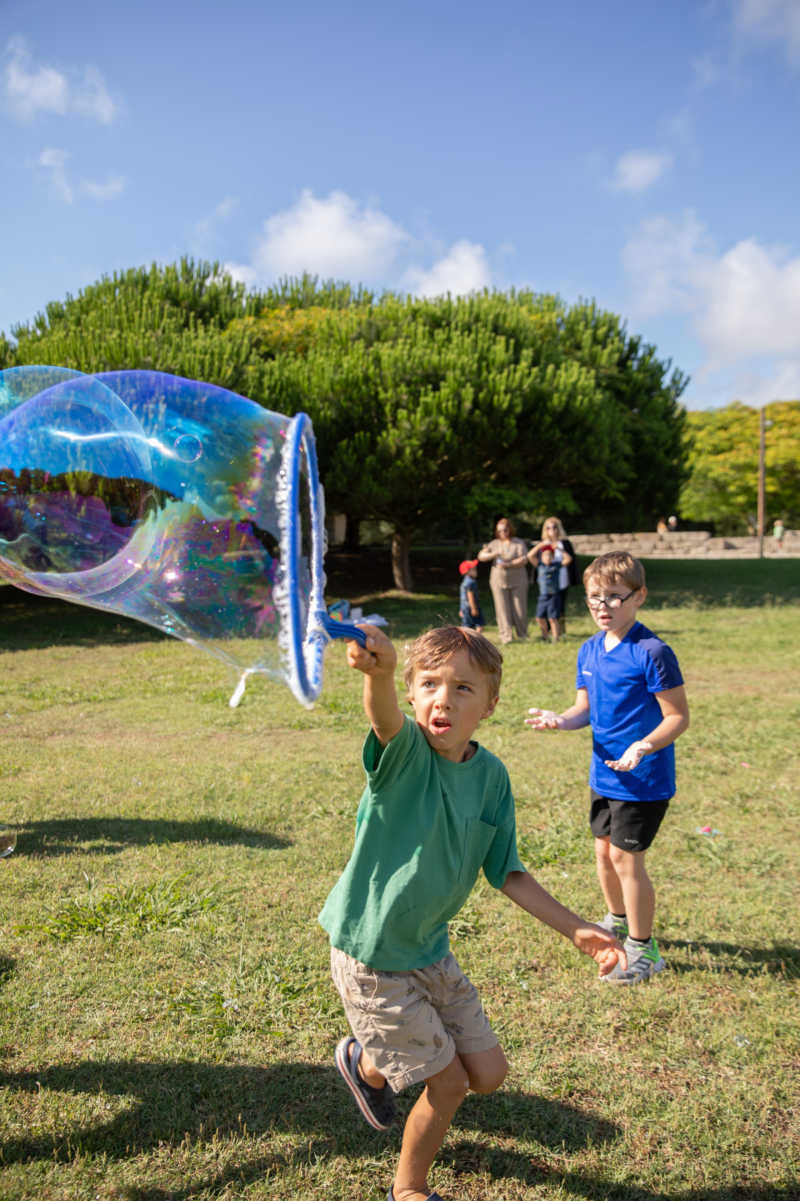 Park birthday photo shoot with kids having fun and soap bubbles in the air