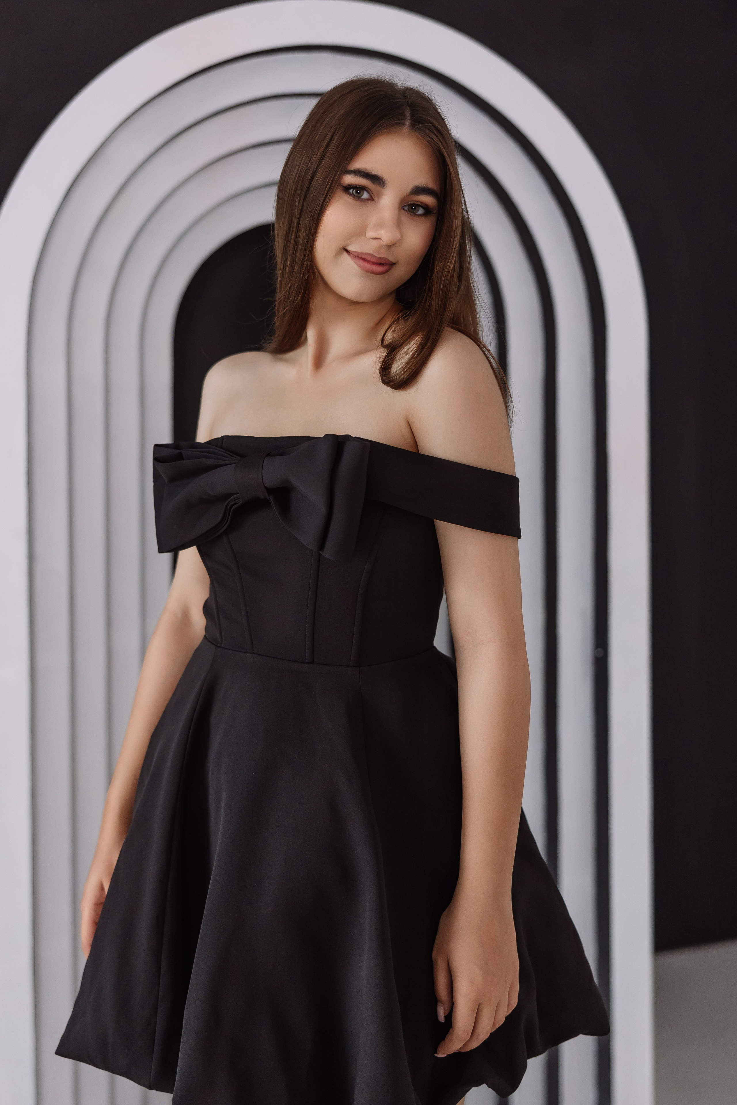 студийная фотосессия — девушка в черном платье возле арки