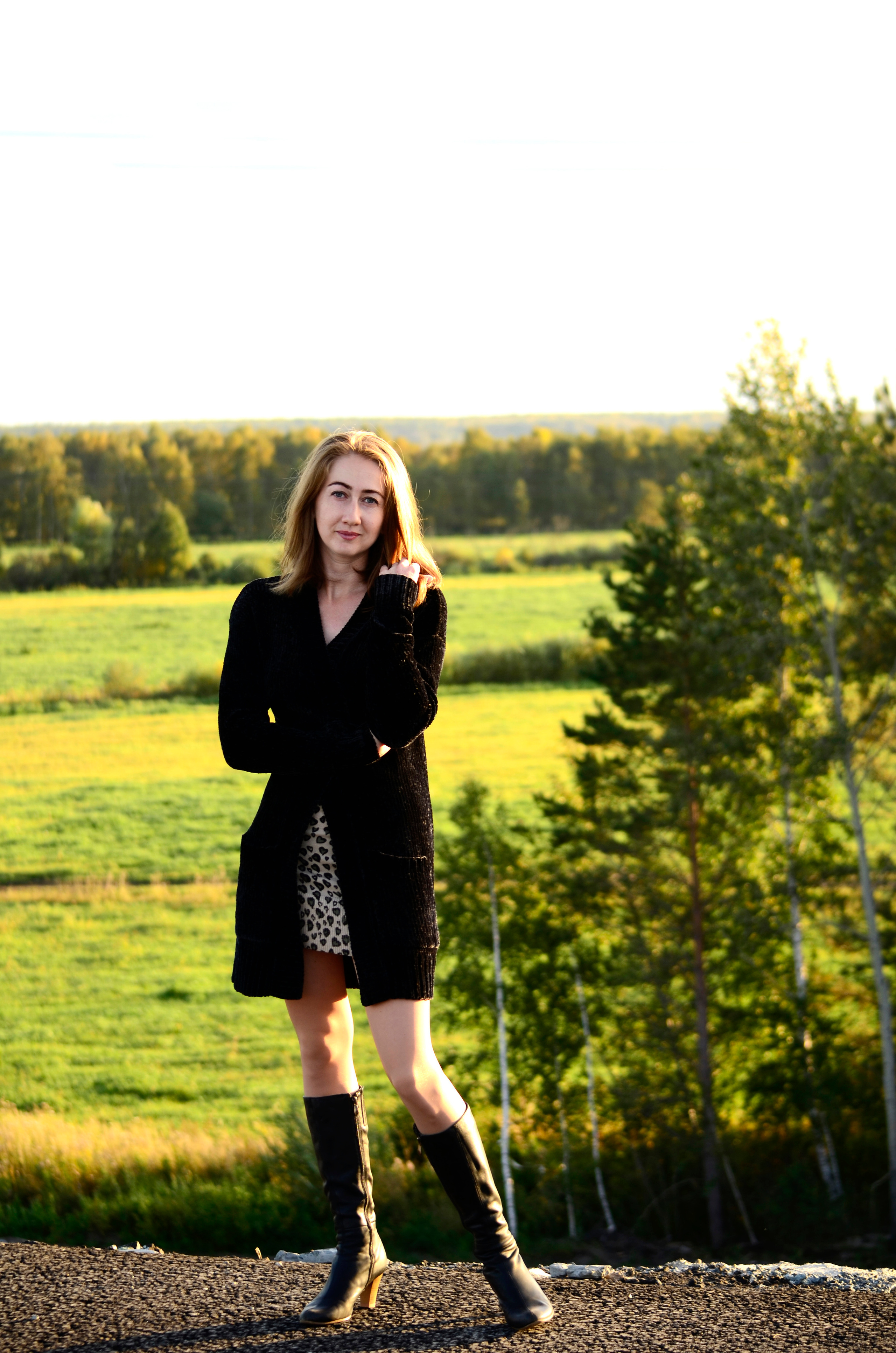 Девушка в кардигане и высоких сапогах