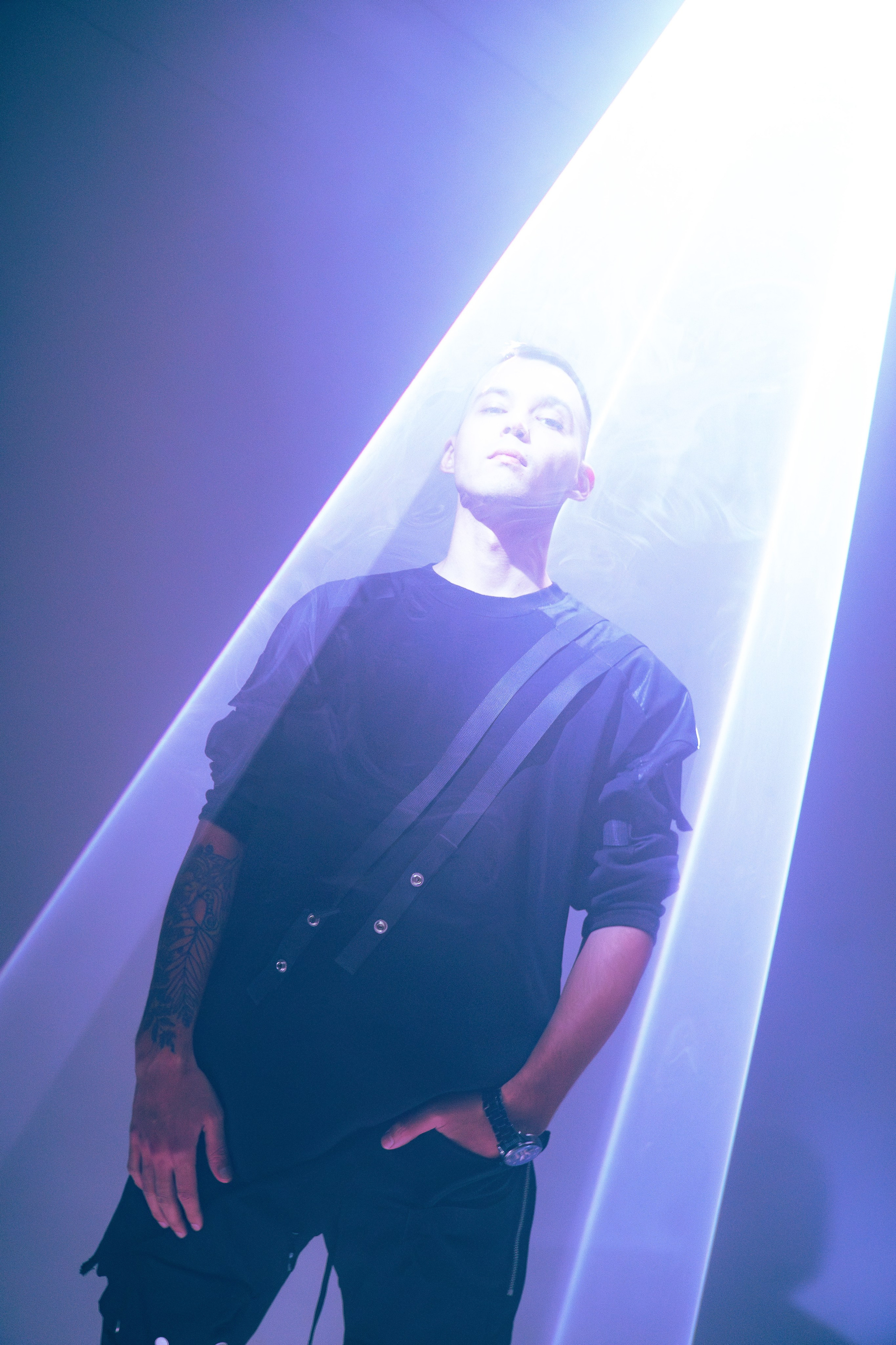 Мужчина в центре студии, окружённый белыми световыми полосами