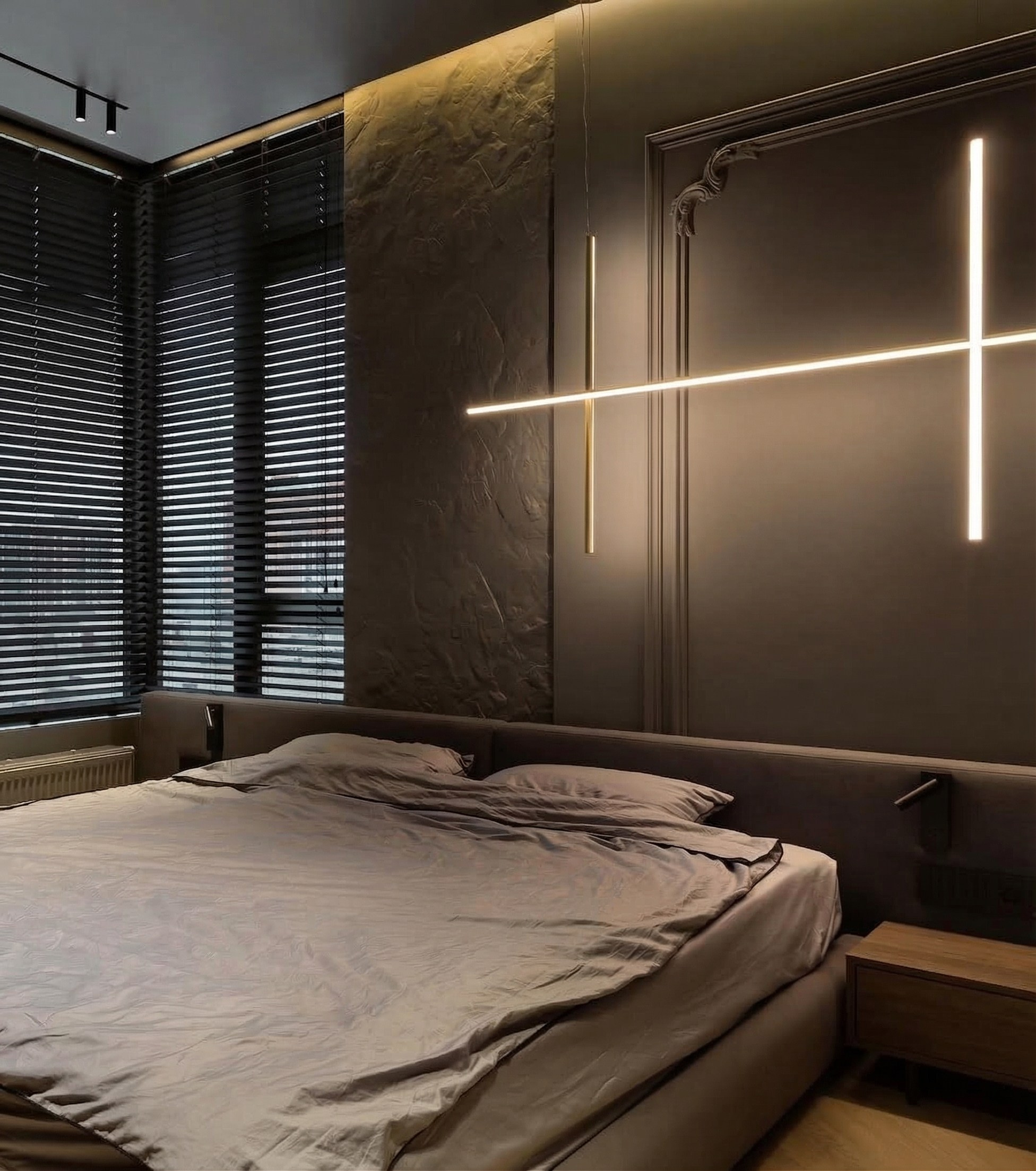 Мастер-спальня от Валерии Котович: сочетание скальной фактуры, неоклассических молдингов и линейного светодиодного светильника над кроватью в темно-сером интерьере.