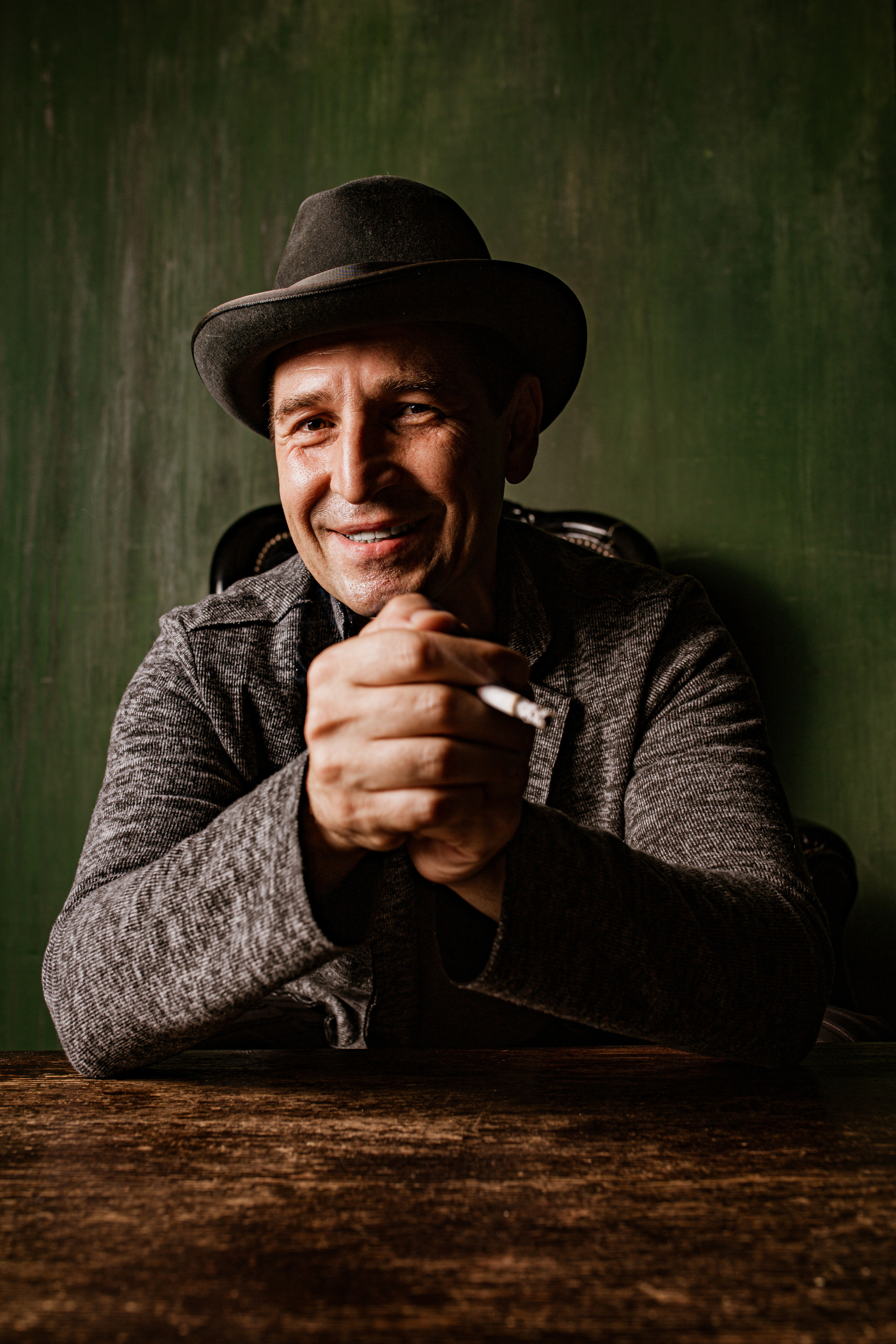 Актёр Олег Карин в шляпе курит сигарету