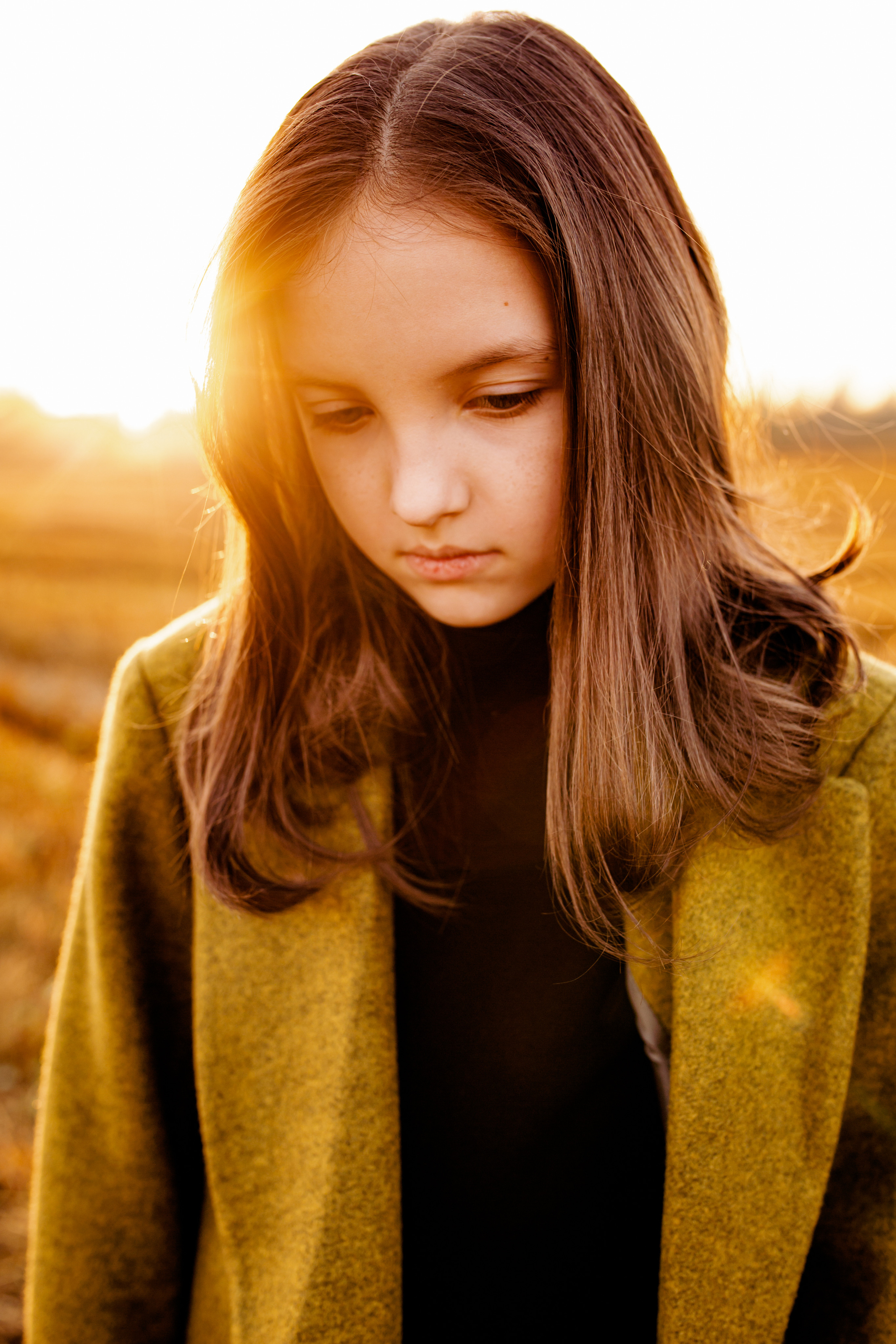Детский портрет на закате. Осенняя фотосессия. Портрет девочки в пальто с длинными волосами.