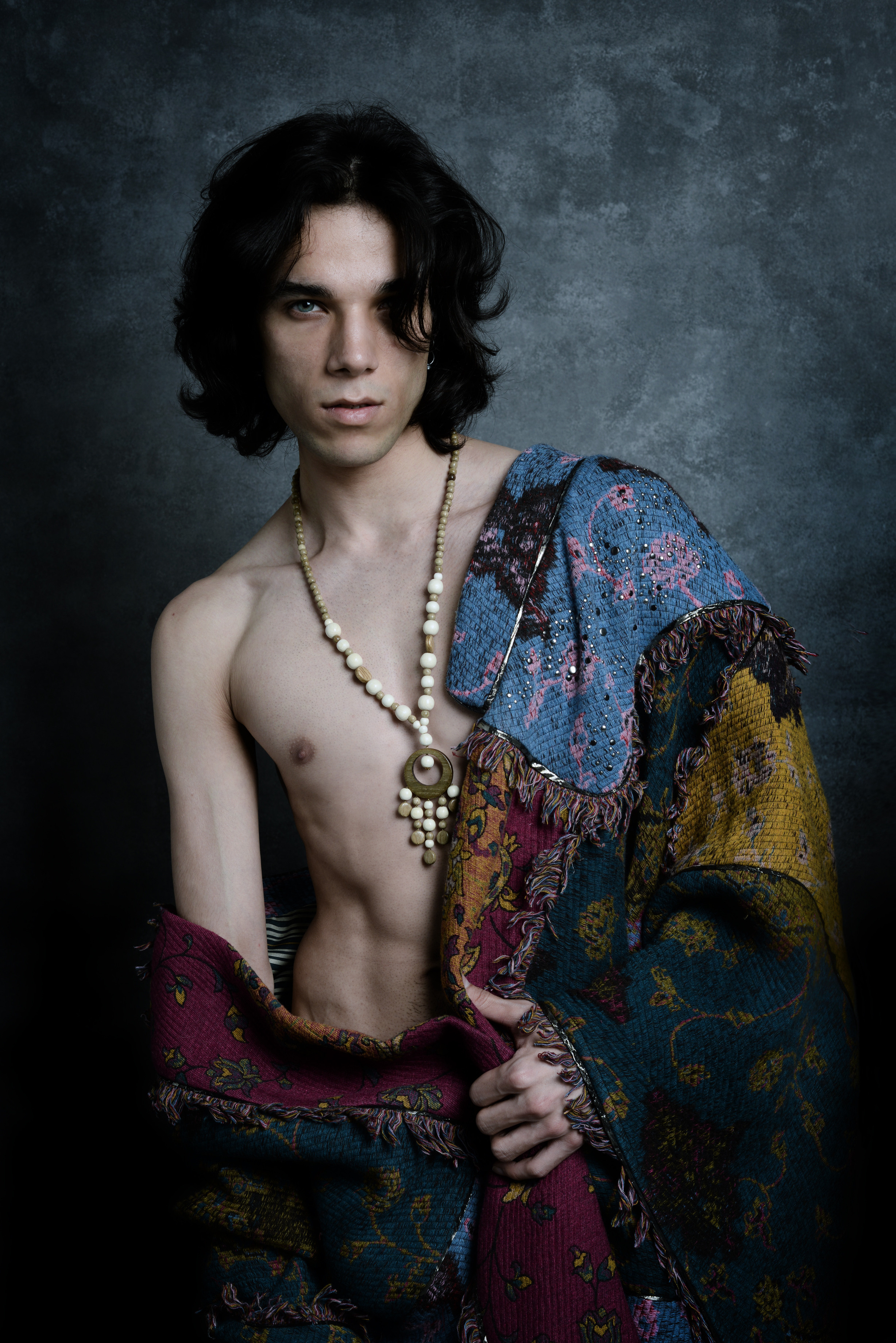 мужская фотосессия в стиле бохо, мужское ню, парень в цветной накидке и с  деревянными украшениями 