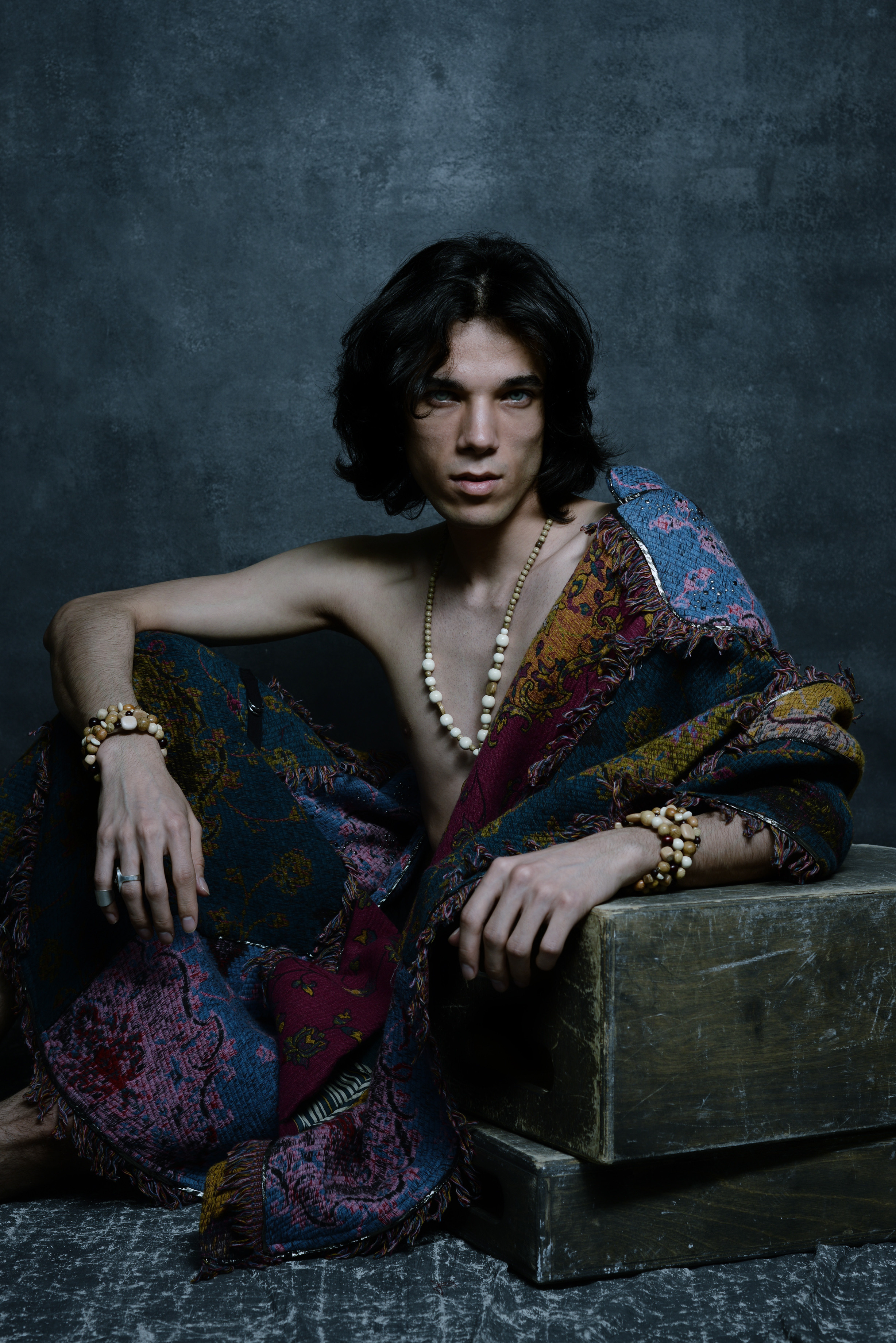 мужская фотосессия в стиле бохо, мужское ню, парень в цветной накидке и с  деревянными украшениями 