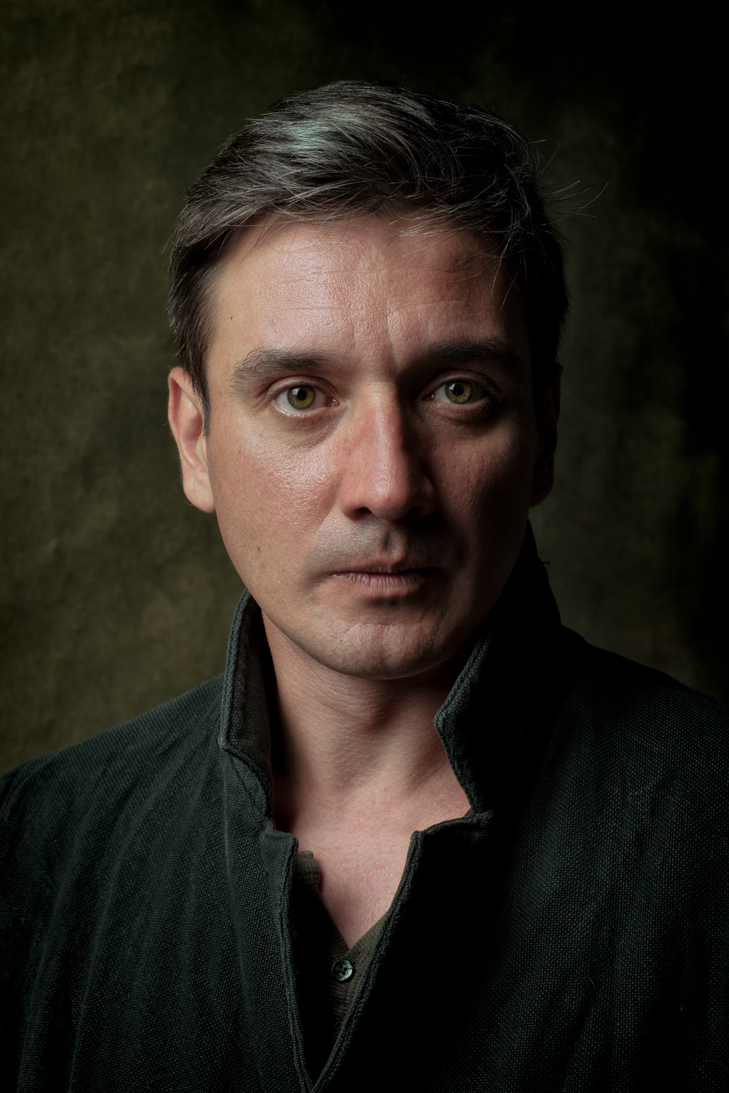 классический мужской портрет в коричневых тонах, мужчина в пальто на зеленом фоне 