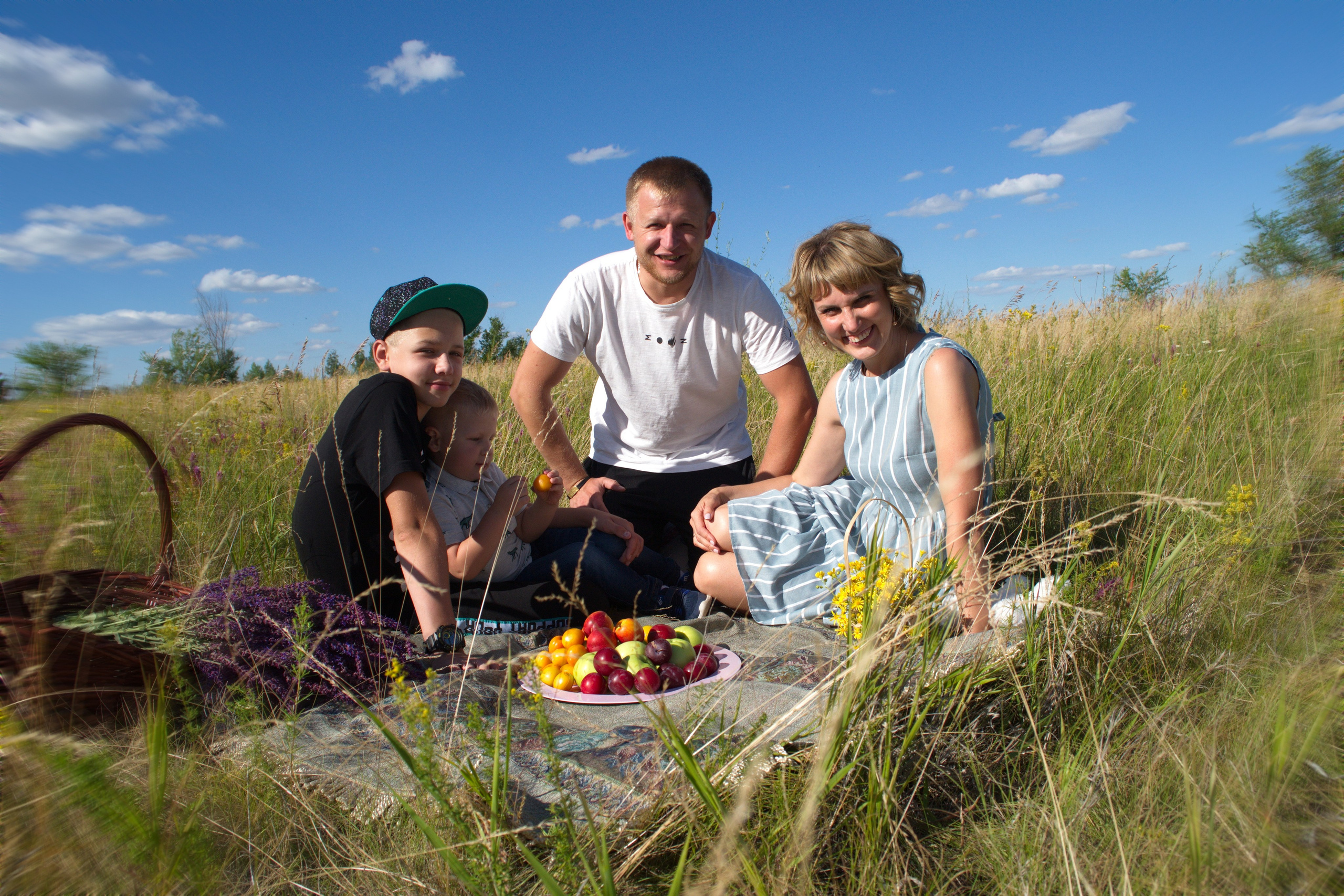 Семейный пикник в поле. Семья позирует фотографу.