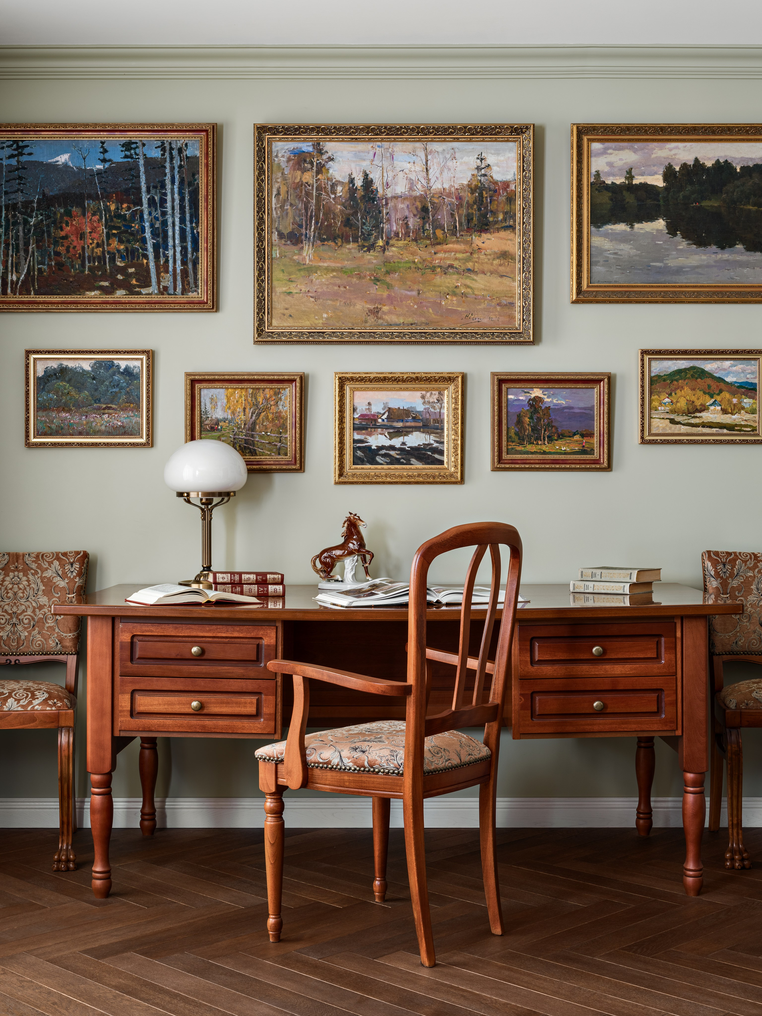 Классический рабочий кабинет с массивным деревянным столом, стулом с резной спинкой и коллекцией картин в позолоченных рамах; уютная атмосфера для работы и чтения. Авторский интерьер Юлии Капункиной и Альбины Терещенко, стилист Алина Нелень, фото Сергея Денисенко.