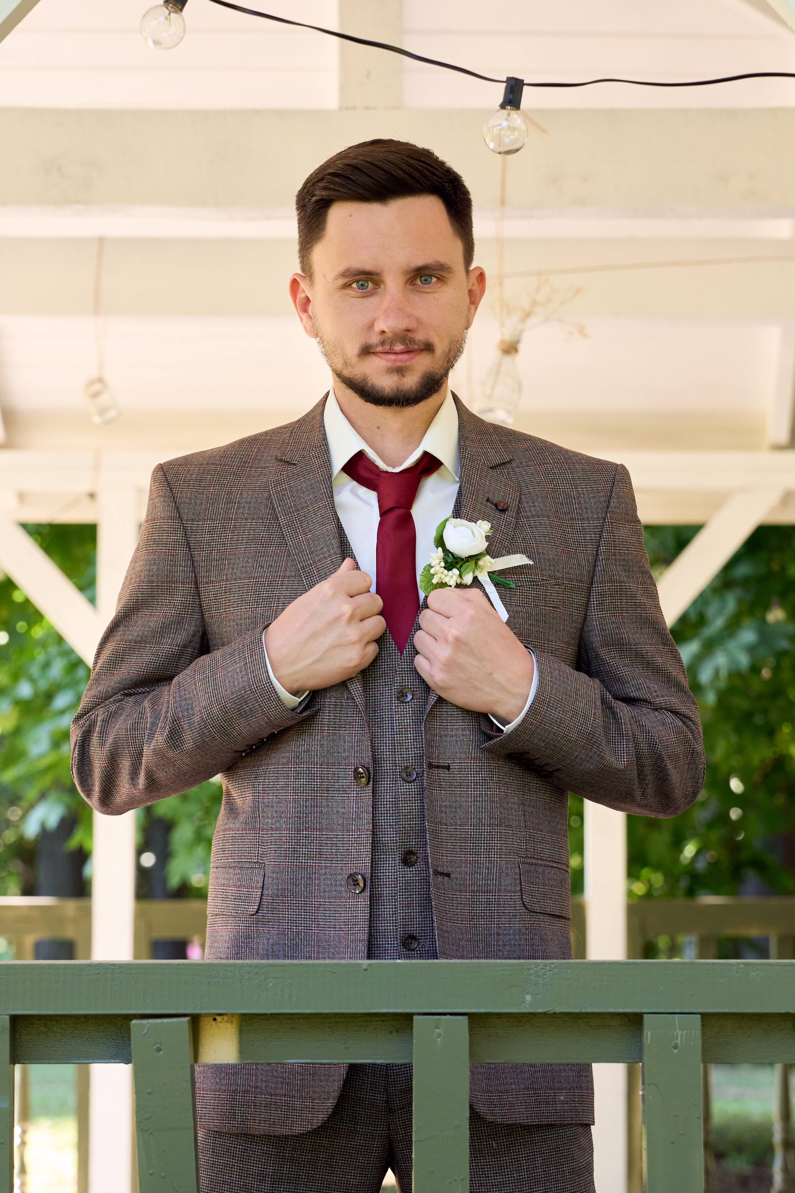 строгий жених в клетчатом пиджаке в беседке