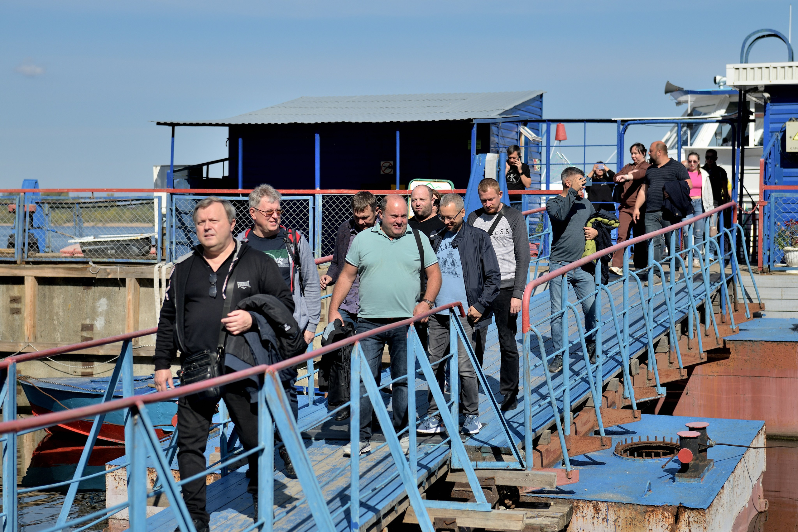 "Сотрудники компании выходят с кораблика на участие в тимбилдинге".