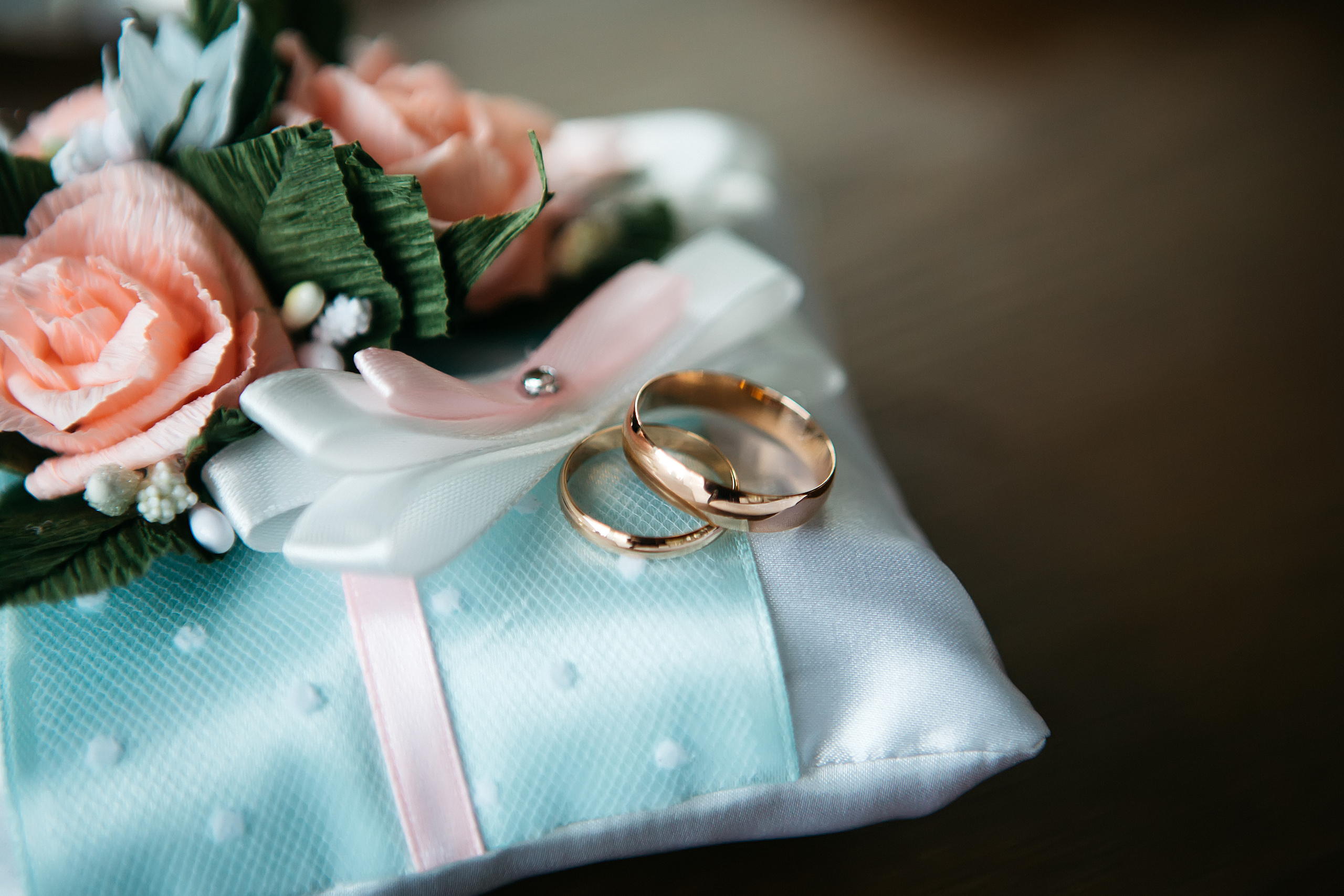 Золотые обручальные кольца на красивой подушечке