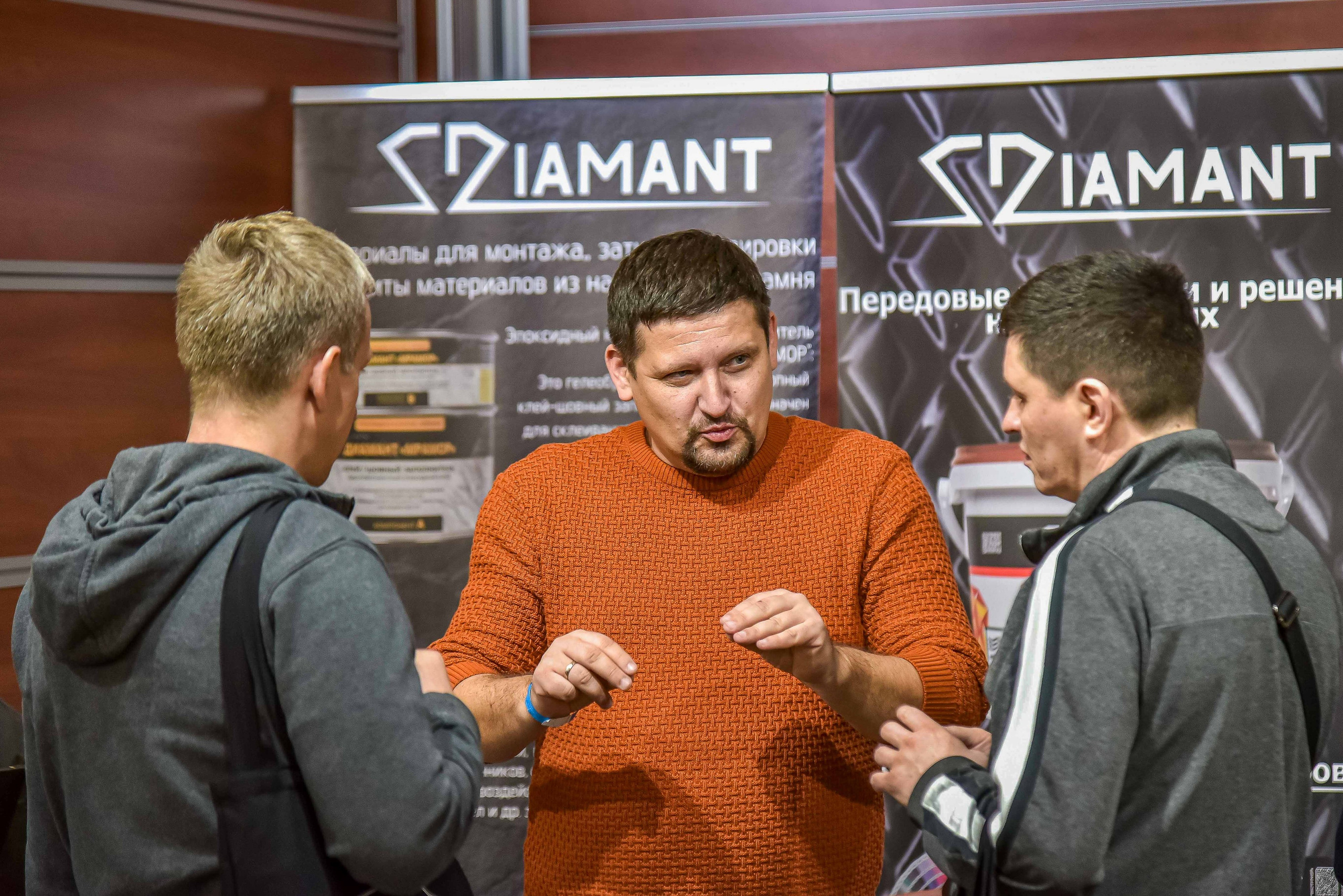 Репортажная съемка с выставки в Москве: снимок передаёт атмосферу общения между представителем компании и посетителями выставки.