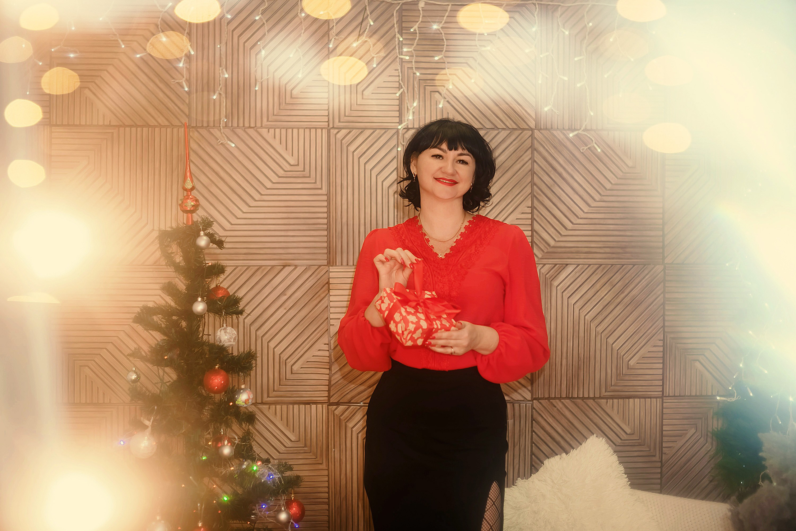 На фото женщина с подарком на новый год.