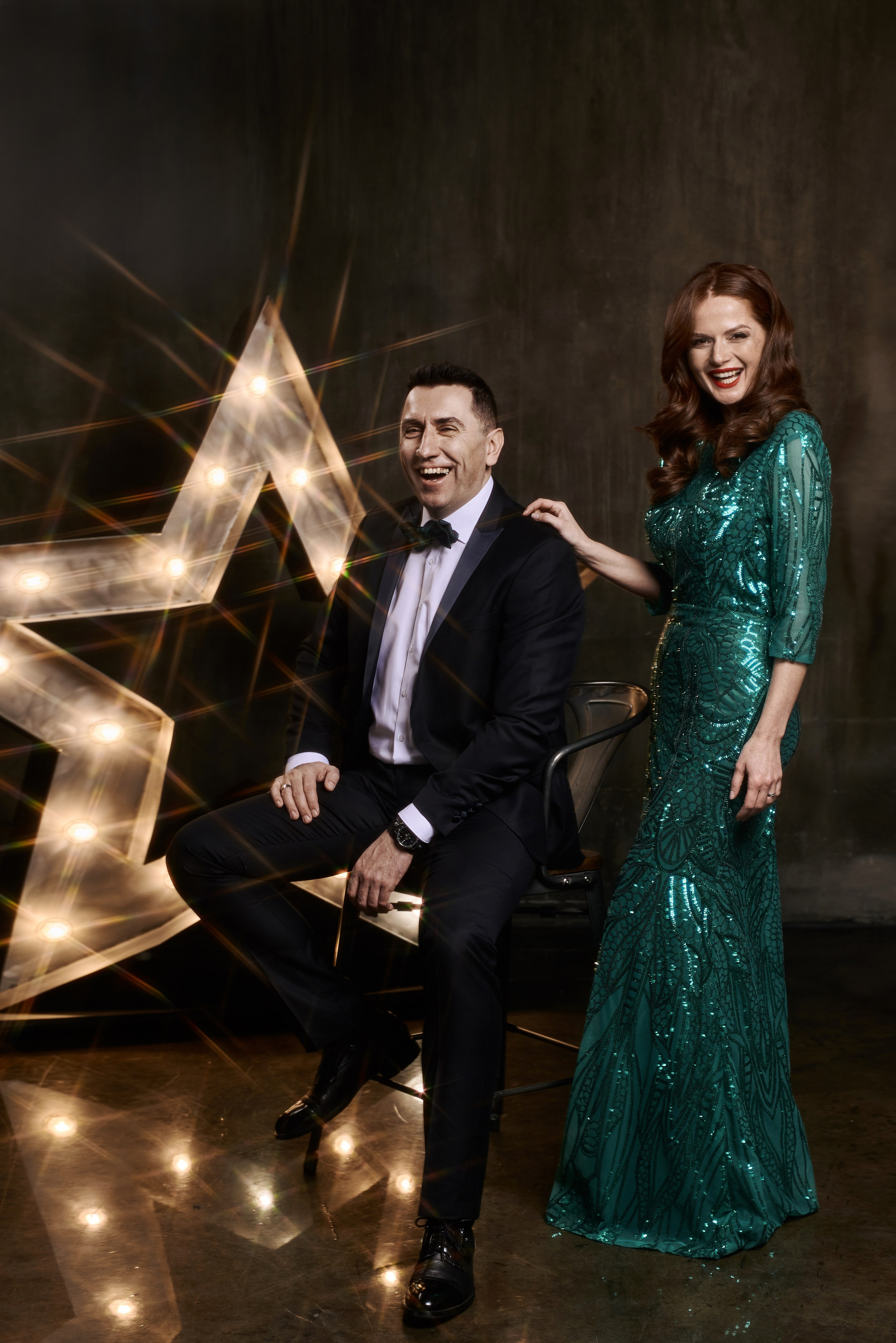 Смеющиеся Елена Ландер и Денис Стойкой позируют фотографу в фотостудии