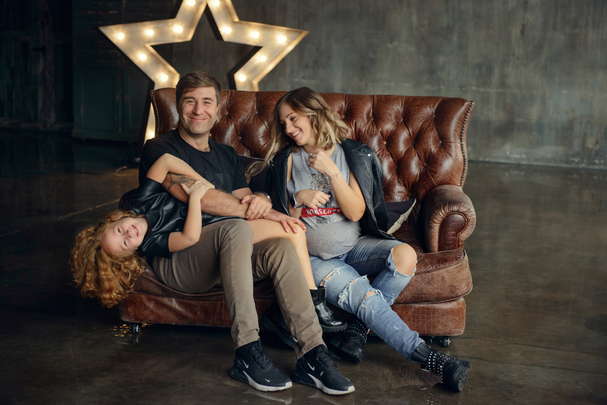 Family photo shoot with a pregnant woman in a loft studio, rock and roll style