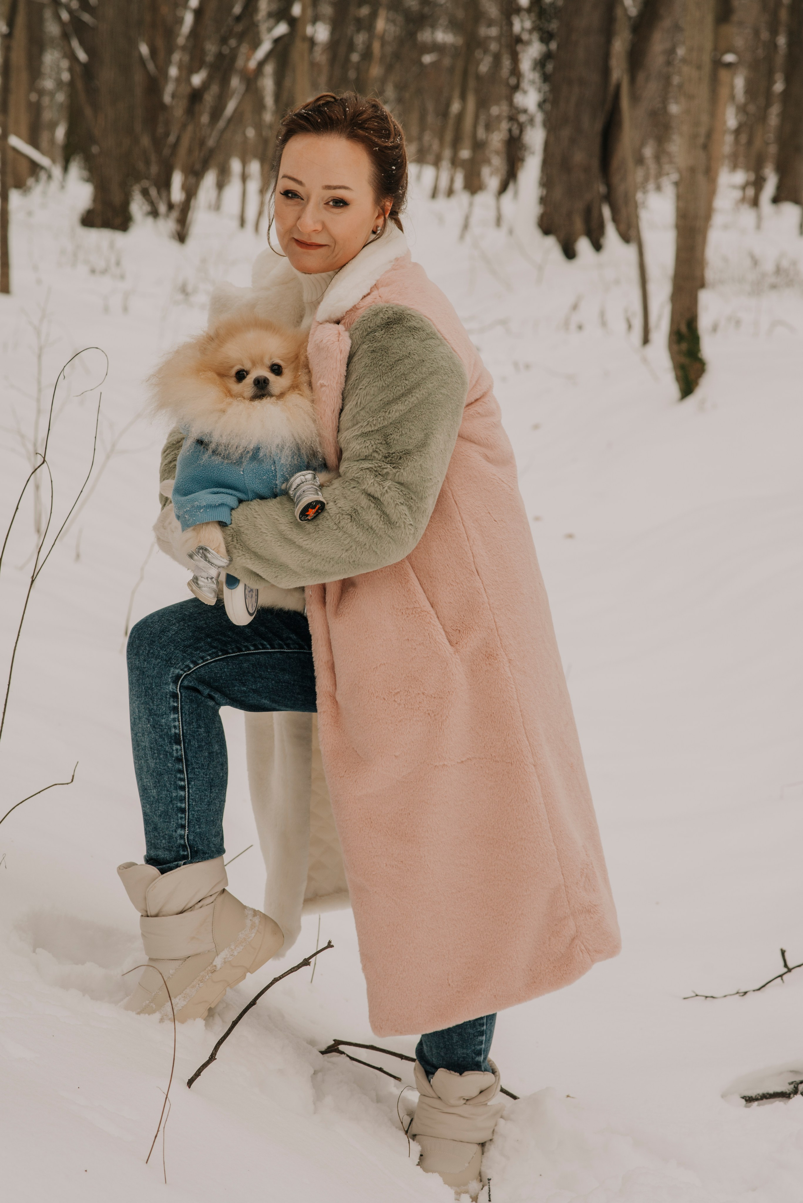 Портрет женщины в розовой с зеленым шубе, держащей на руках шпица в лесу