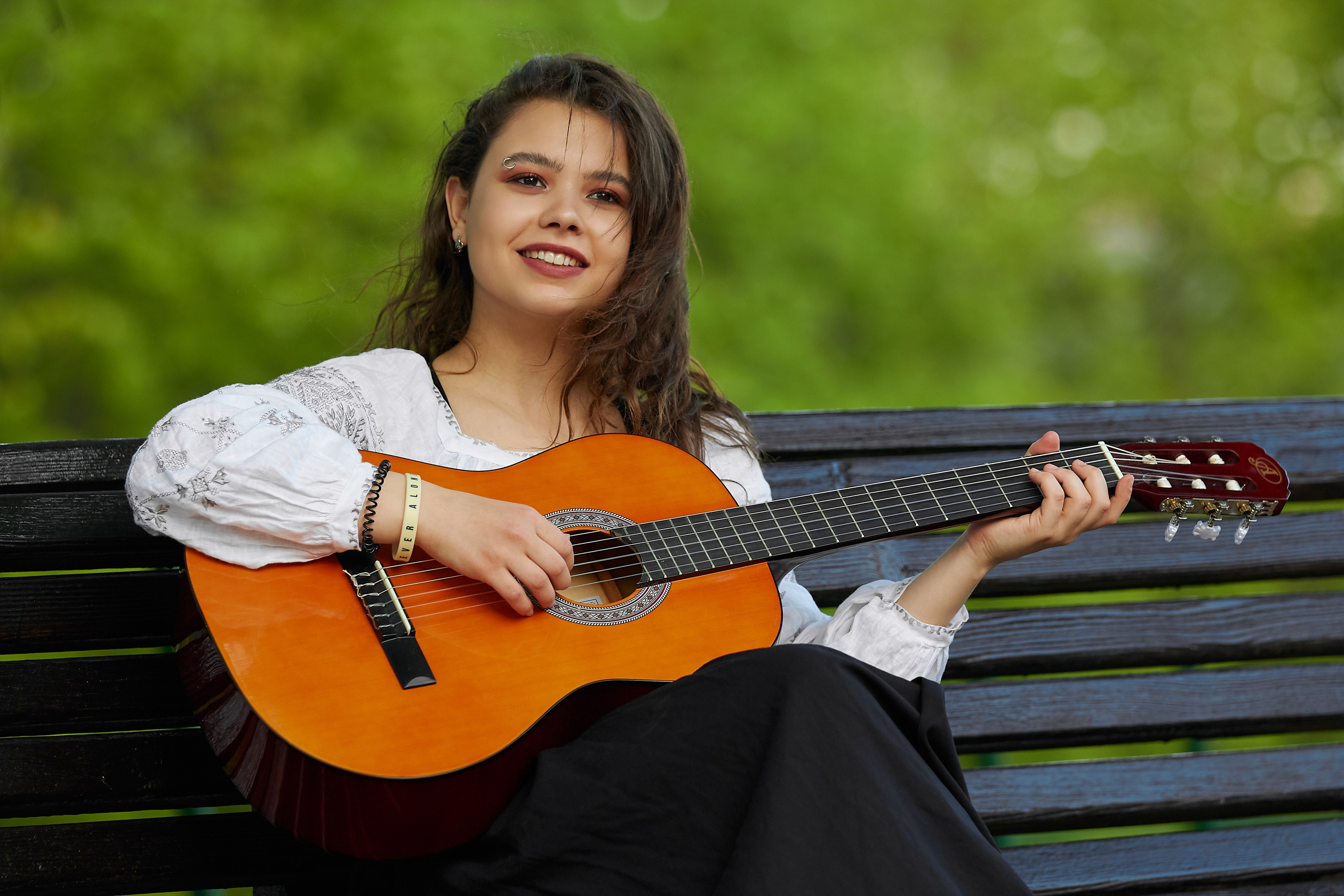 Alt-текст - Девушка играет на гитаре на скамейке в Царицынском парке, весенняя портретная съёмка, естественный свет