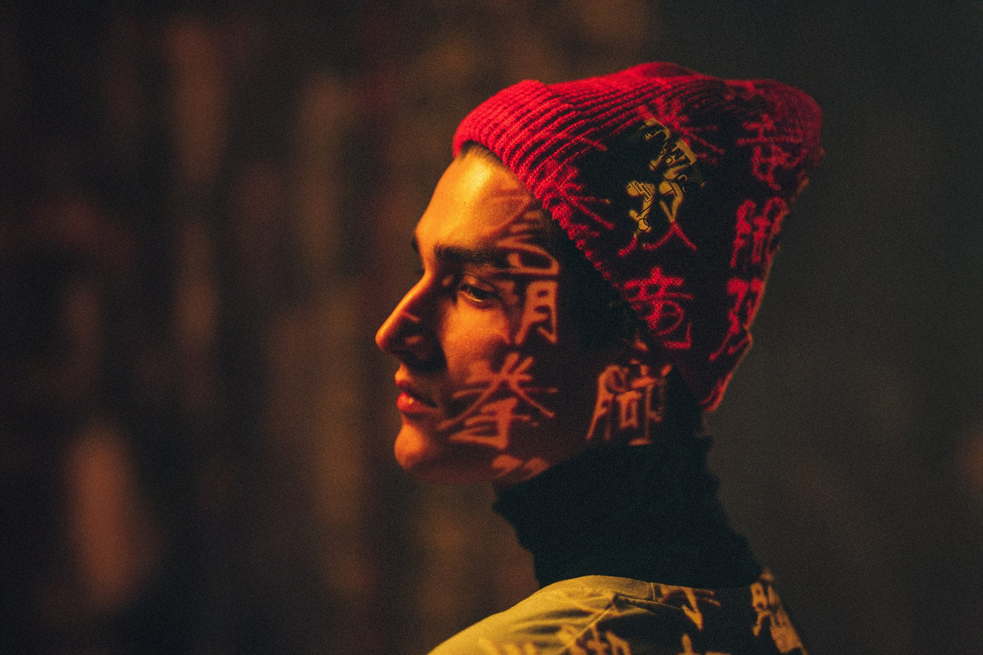 Атмосферный профиль в красной шапке с оранжевыми иероглифами, снятый фотографом из Сочи Галиной Скорик.