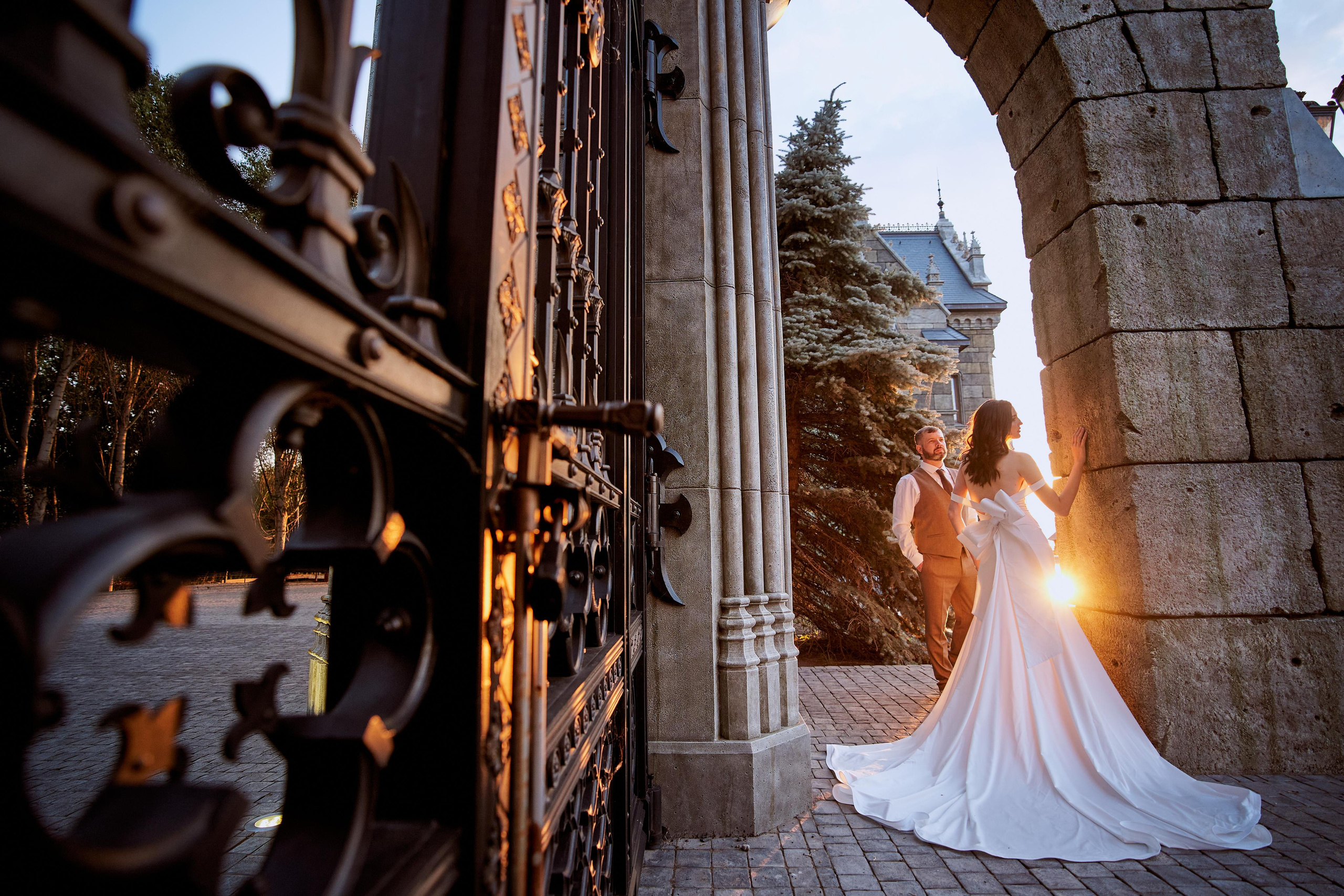 Орнаментальные ворота замка Гарибальди с резной решёткой и мягким вечерним светом, подчеркивающим готический стиль.