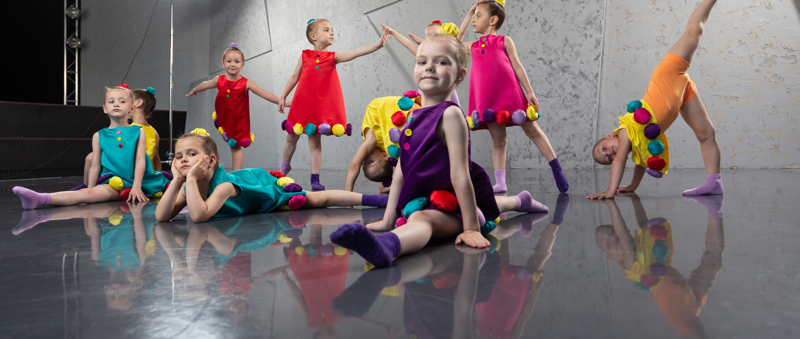 Яркие фотографии детей-балеринов в костюмах на фоне танцевального зала, детская балетная фотосессия
