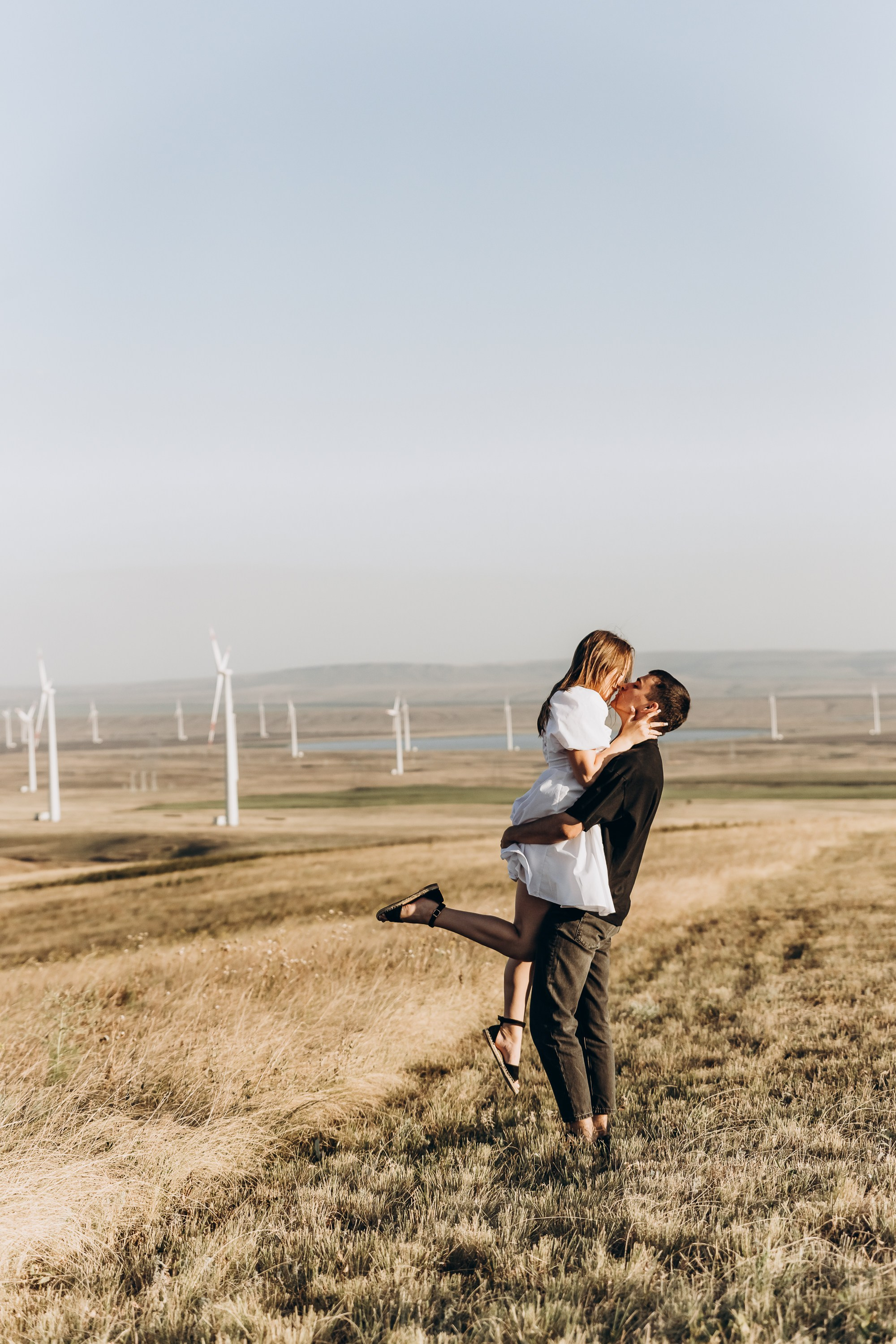 Парень и девушка смеются, обнимаясь на фоне городской улицы