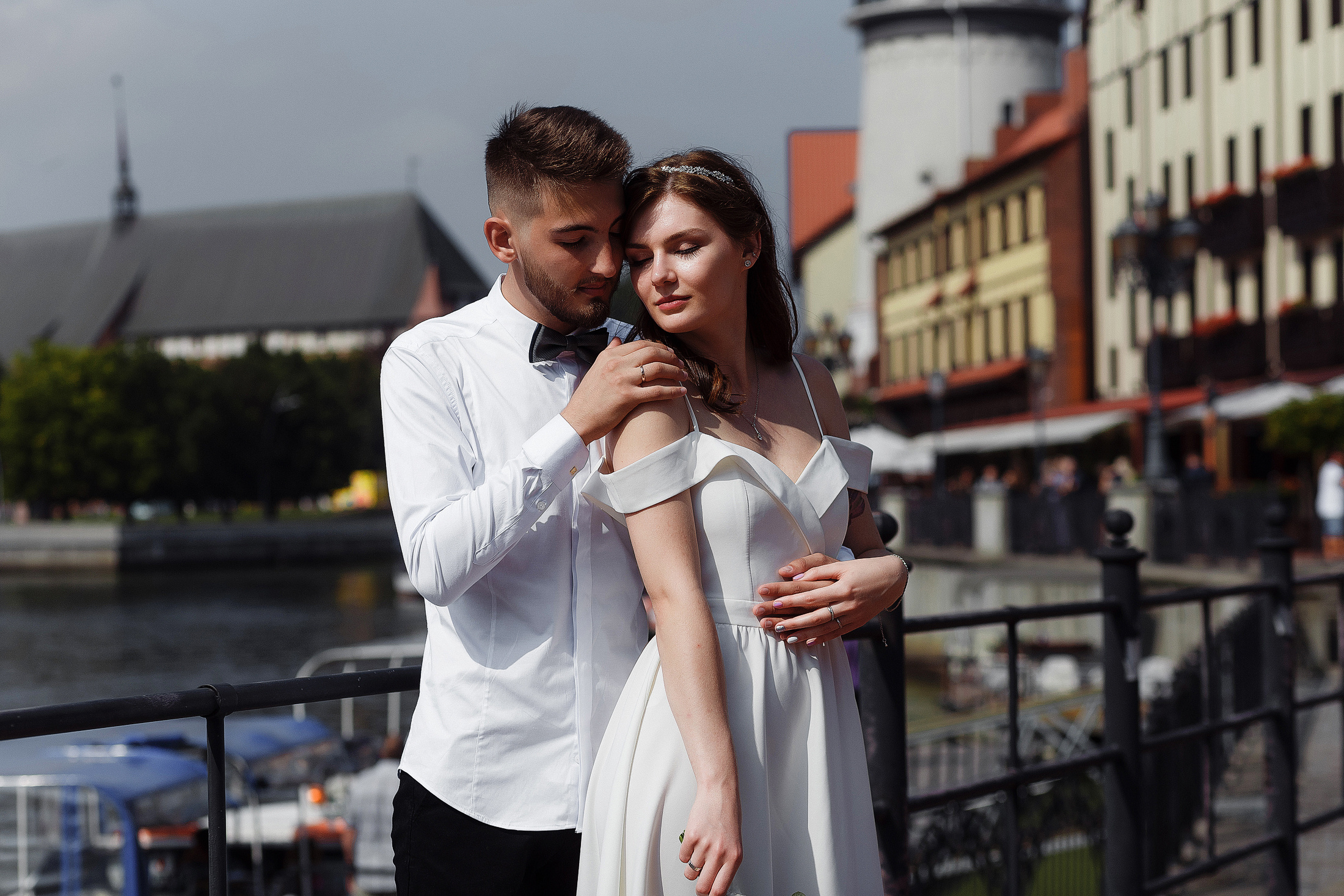 Молодожены обнимаются на Рыбной деревне в Калининграде