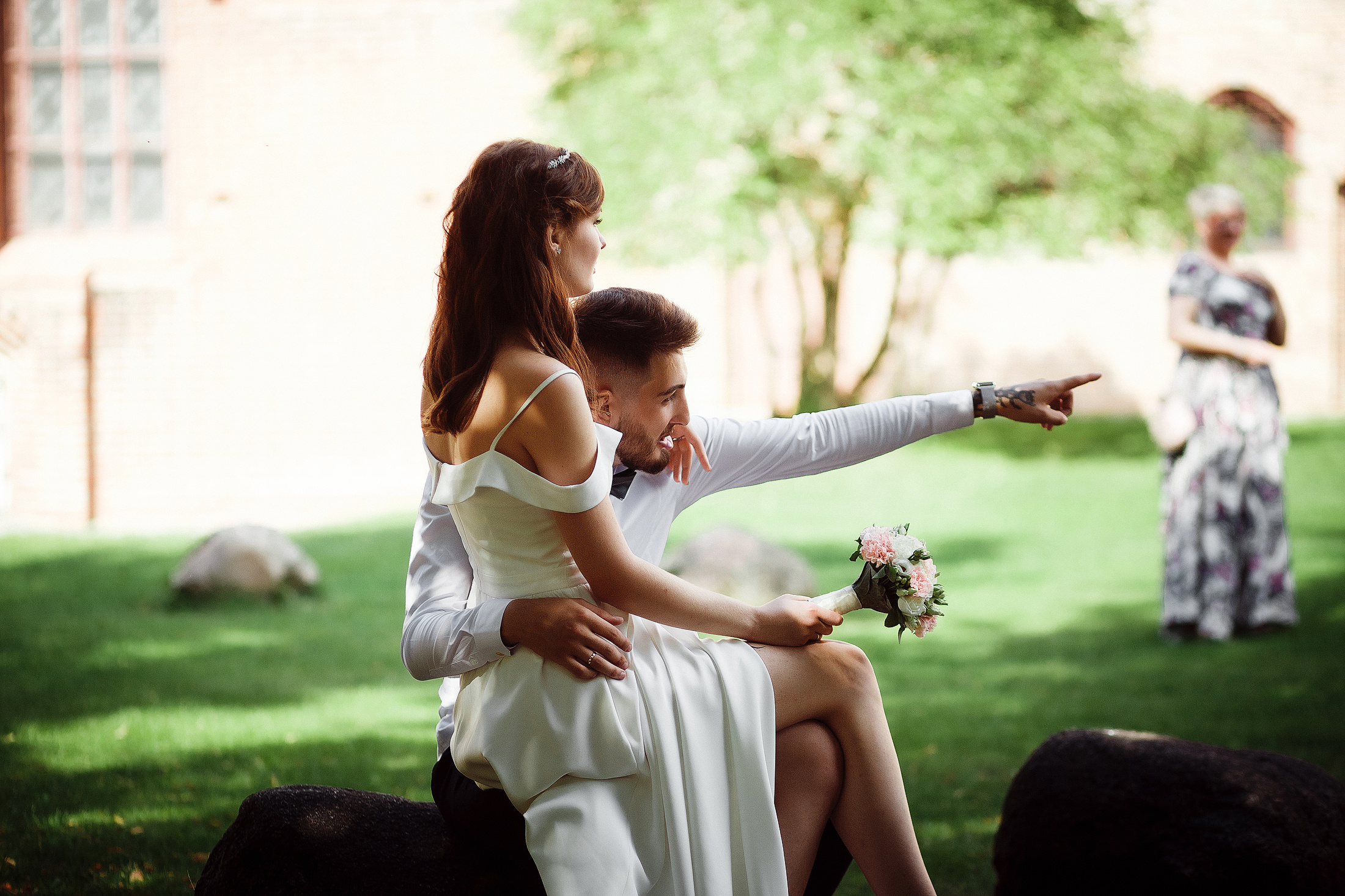 Пара молодоженов сидит в тени в летний жаркий свадебный день