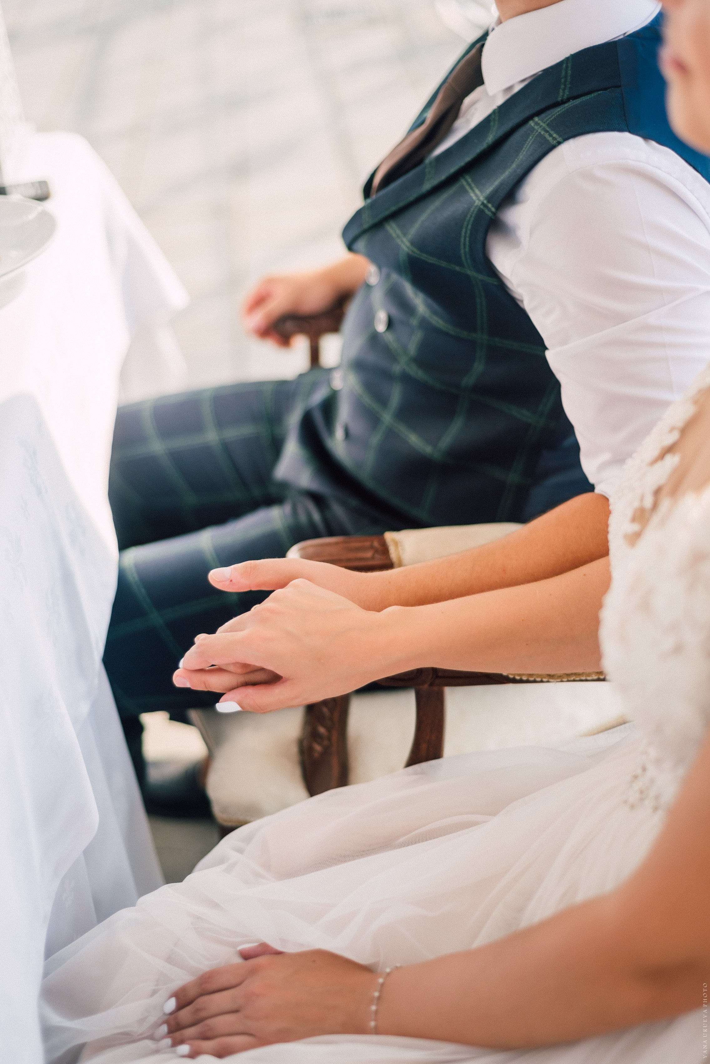 Жених и невеста держатся за руки на банкете