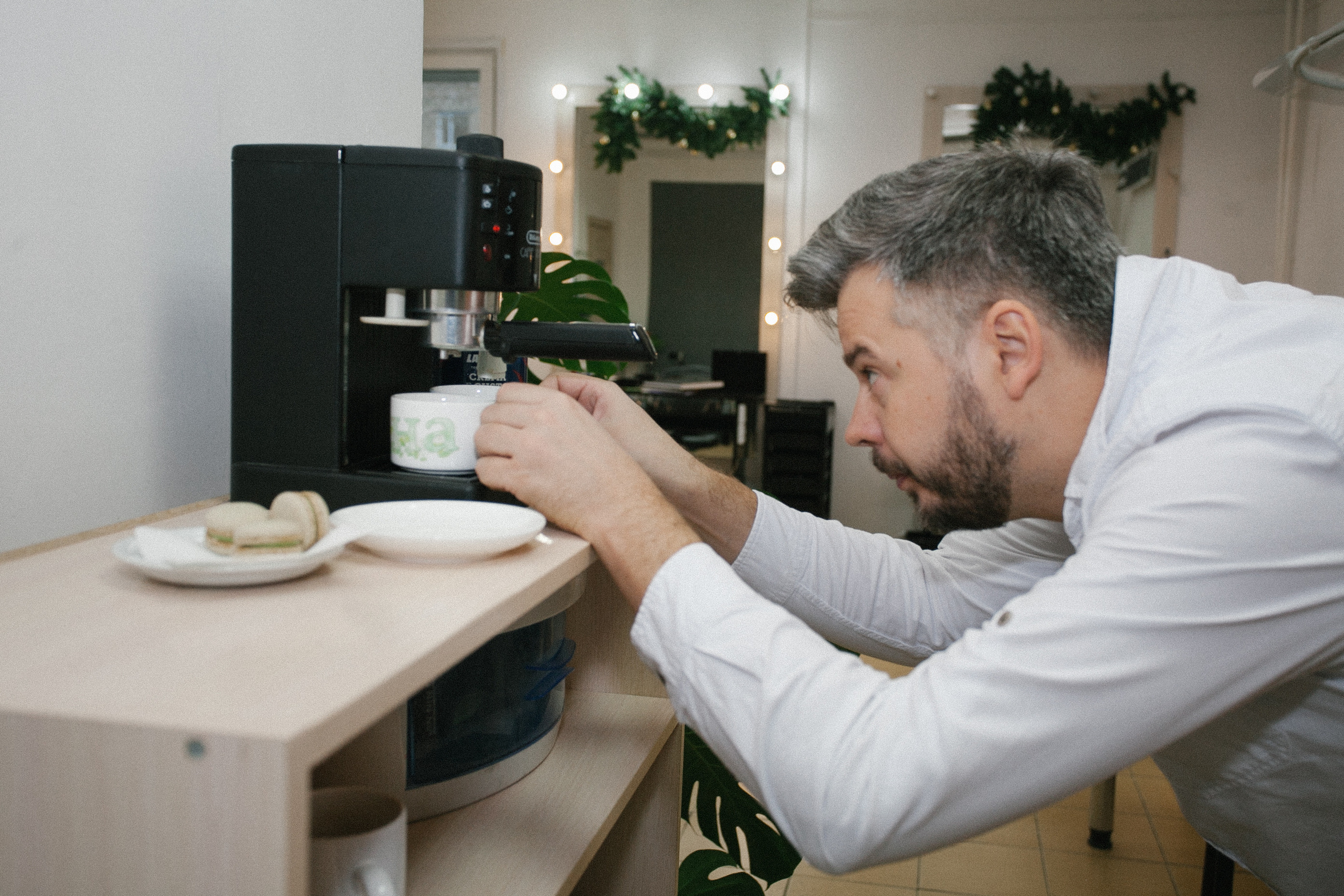 парикмахер мужчина салон  варит кофе машина