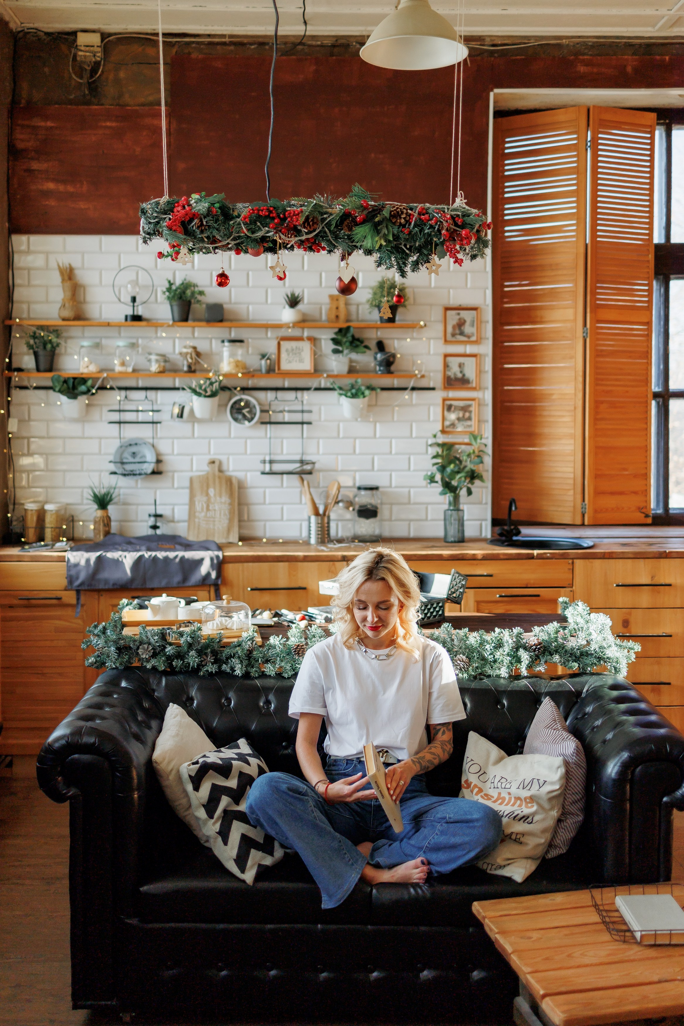 девушка сидит на диване и читает книгу