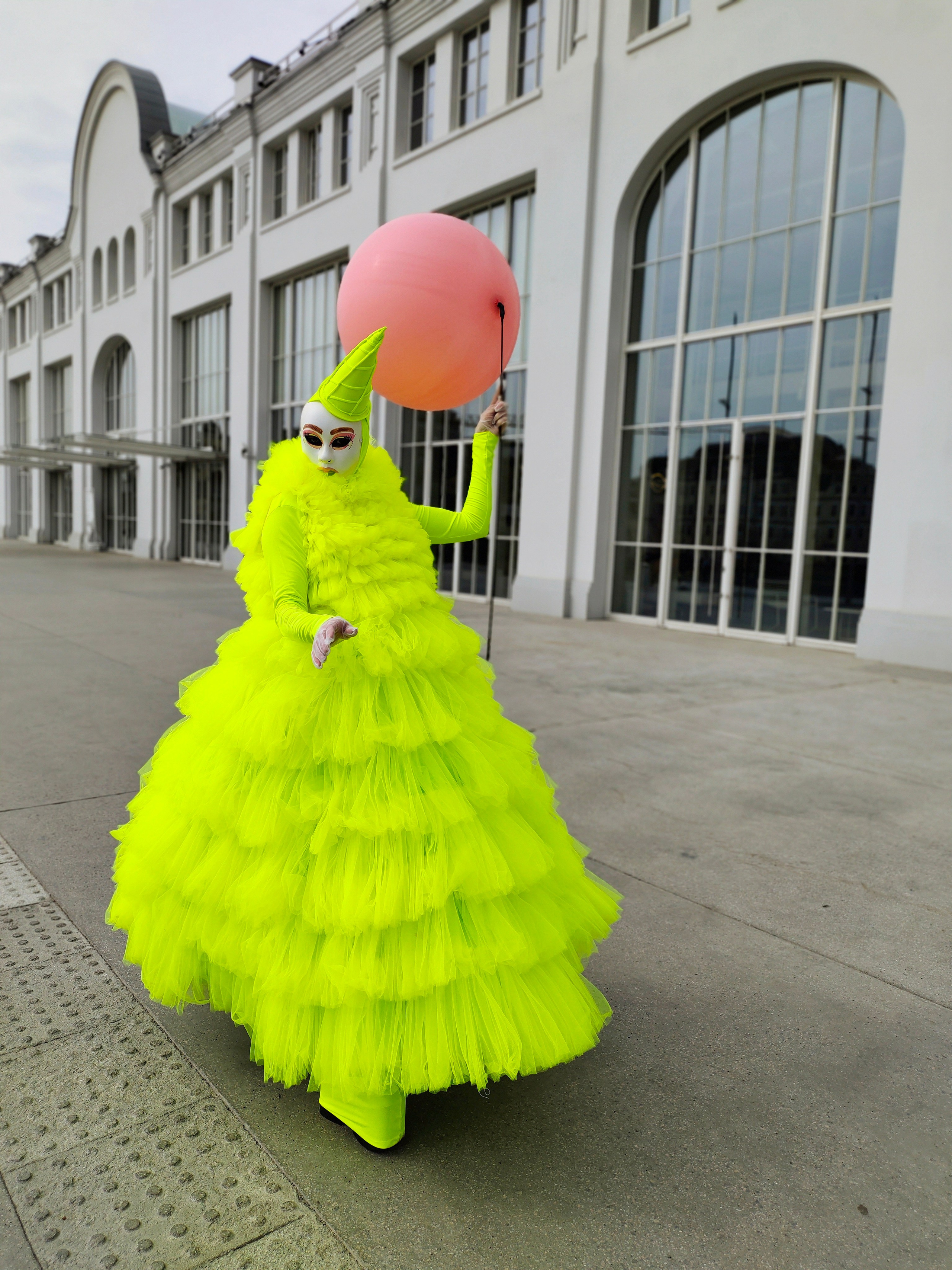 Мим с воздушным розовым шаром на встречает детей на детский праздник.