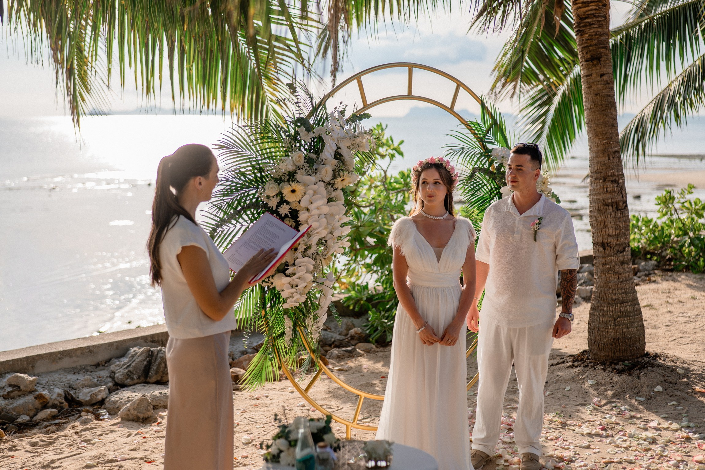 Bride and groom exchanging vows on a private sunset beach