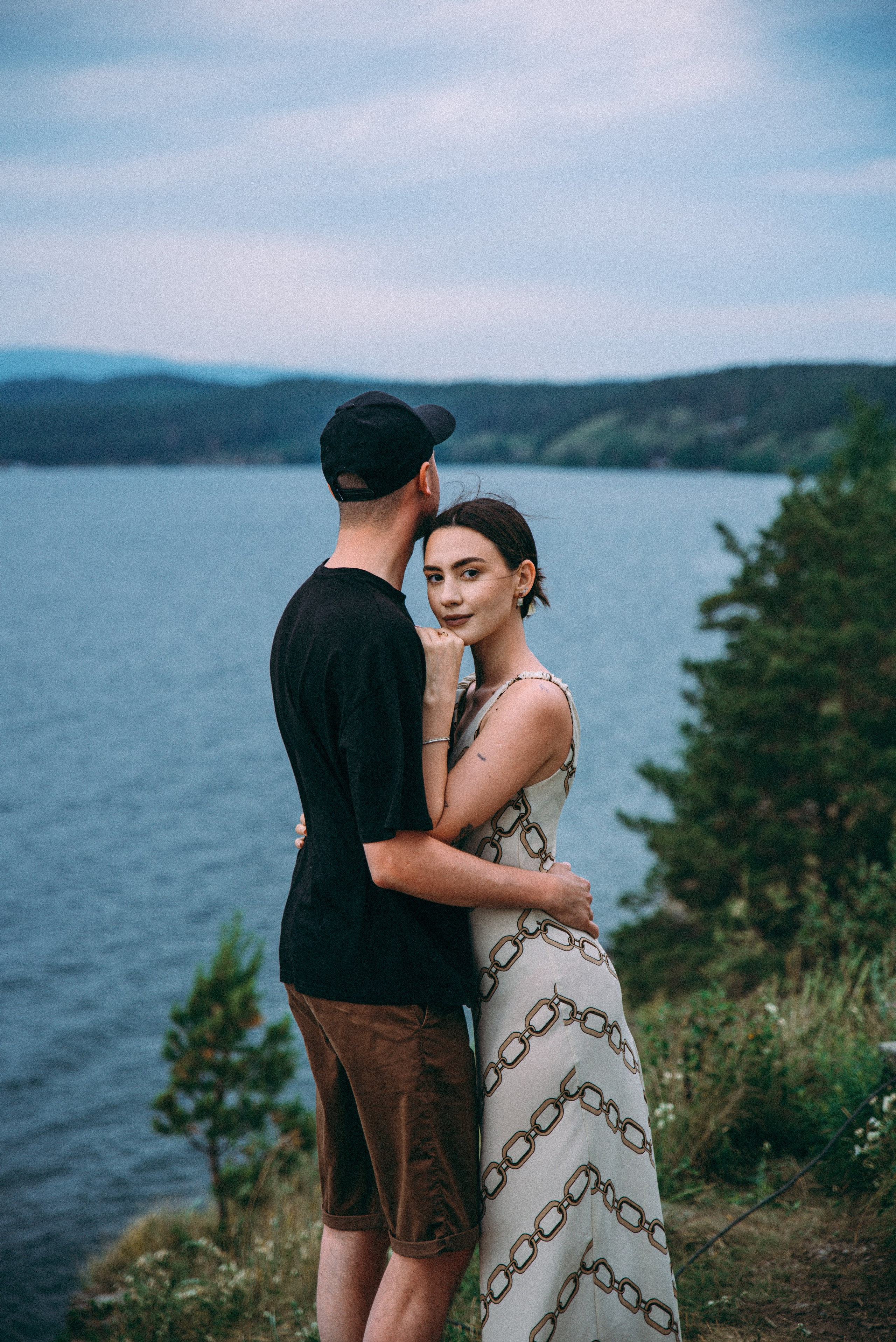 пара влюбленных обнимается на берегу у обрыва