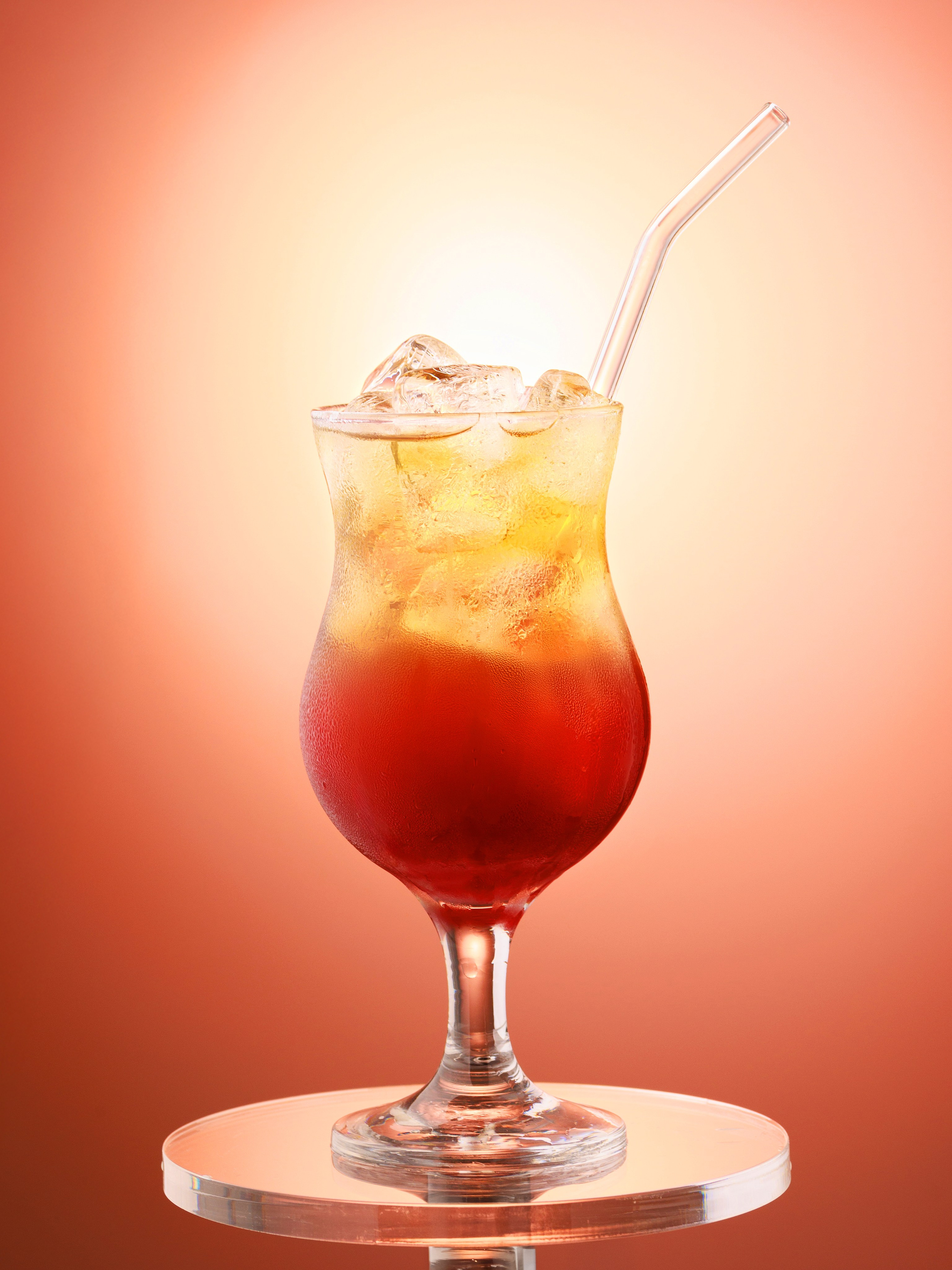 Двухцветный напиток со льдом на фоне солнца. Фудфото лимонада. Фудстайлинг напитков.