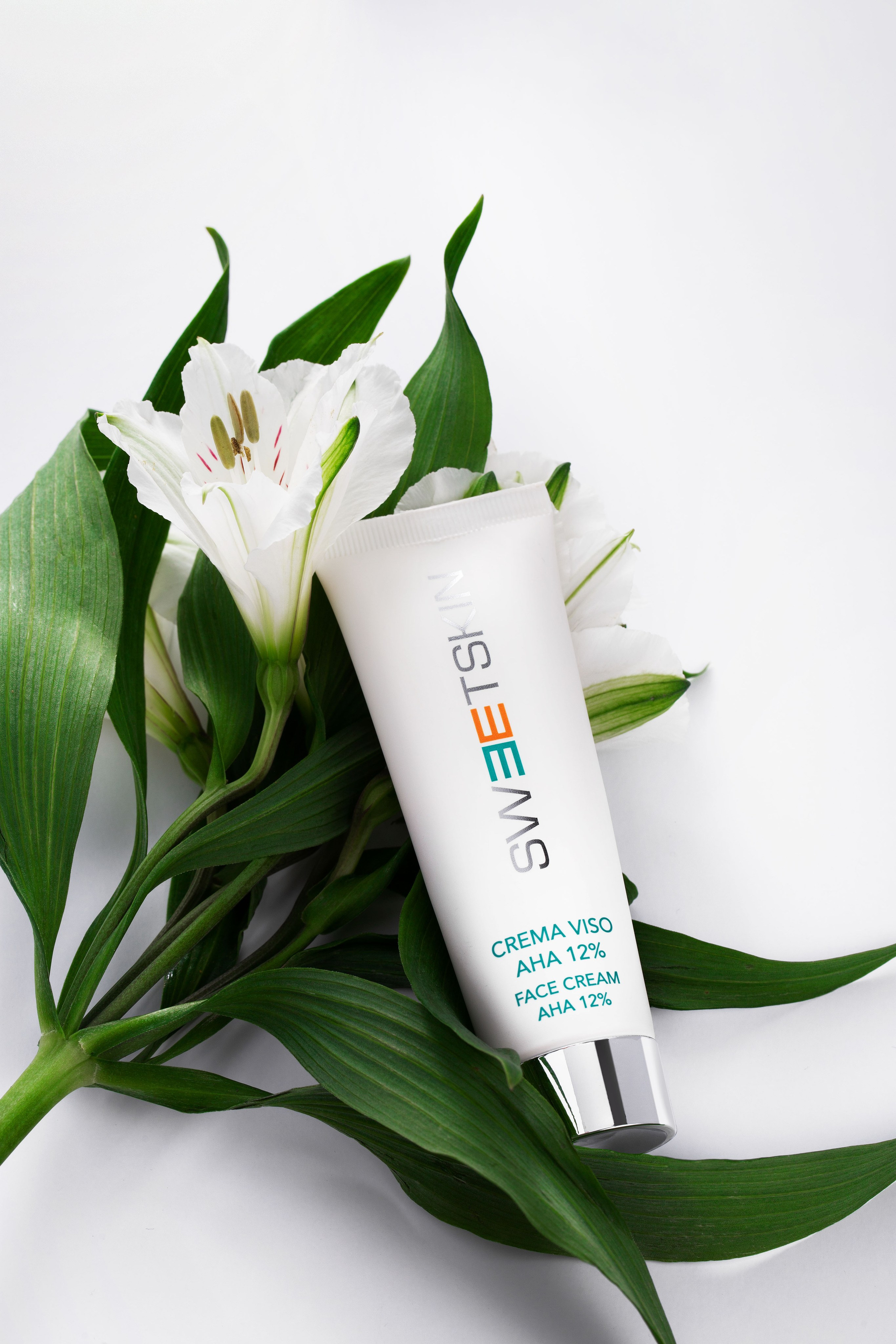 предметный фотограф косметики делает имиджевое фото с цветами и кремом для лица