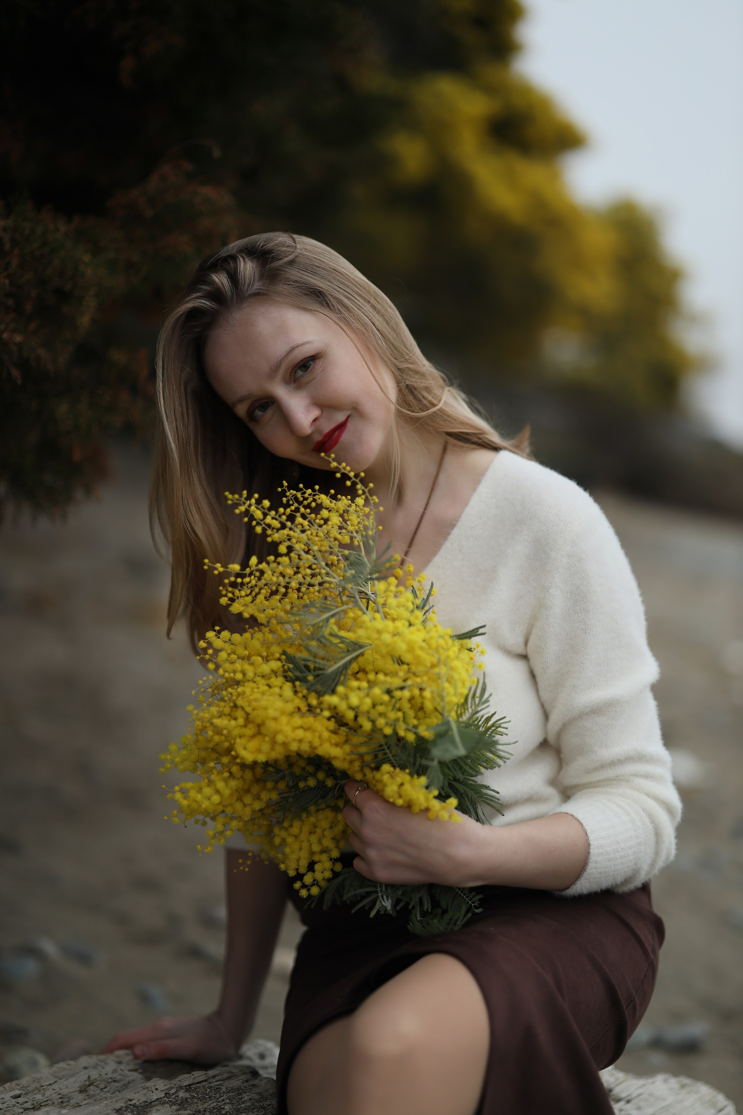 простая женщина фотографируется с мимозой в Абхазии