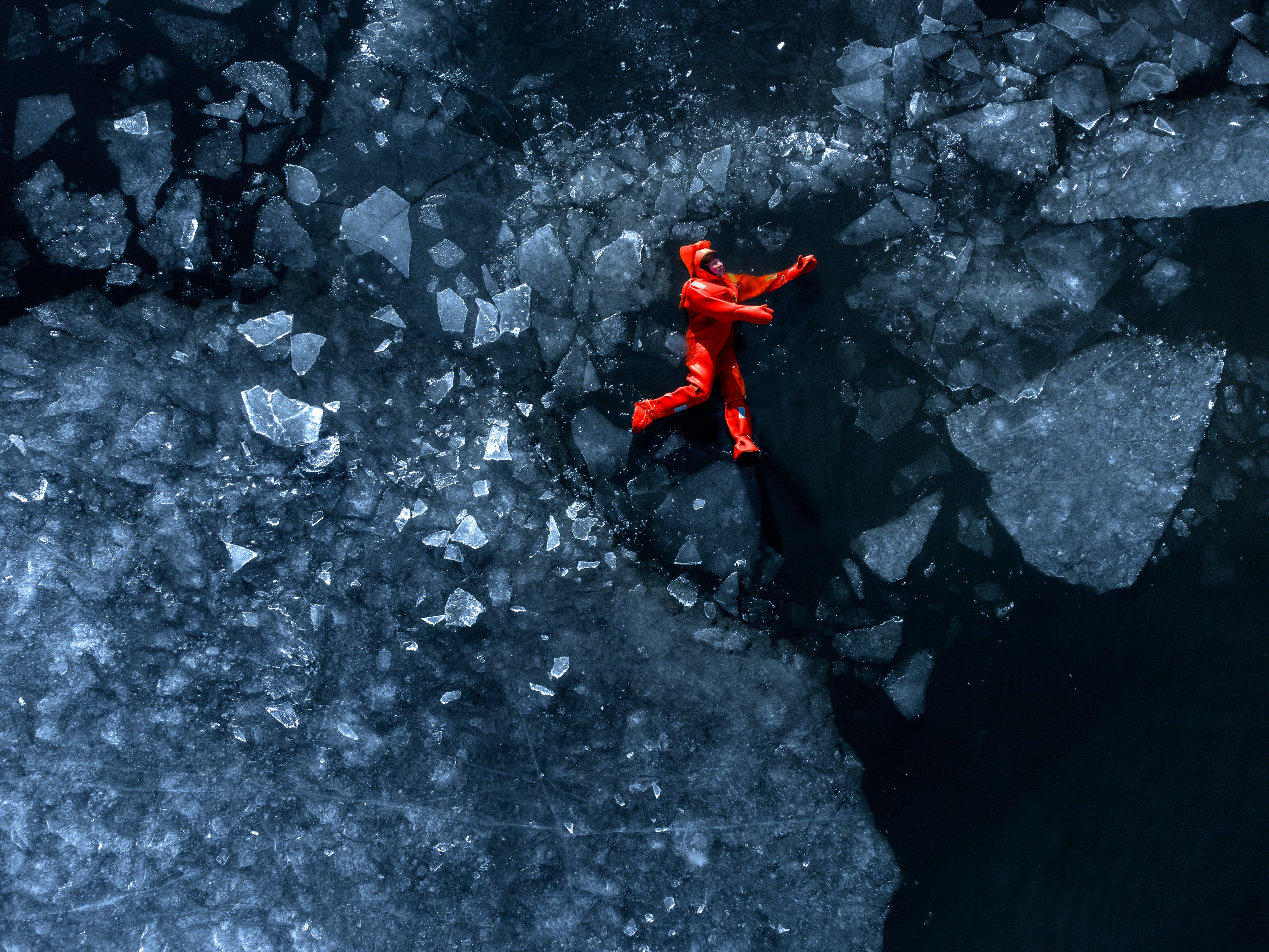 Люди купаются среди льдин, в спасательных оранжевых термо костюмах, айс флоатинг Ярославль