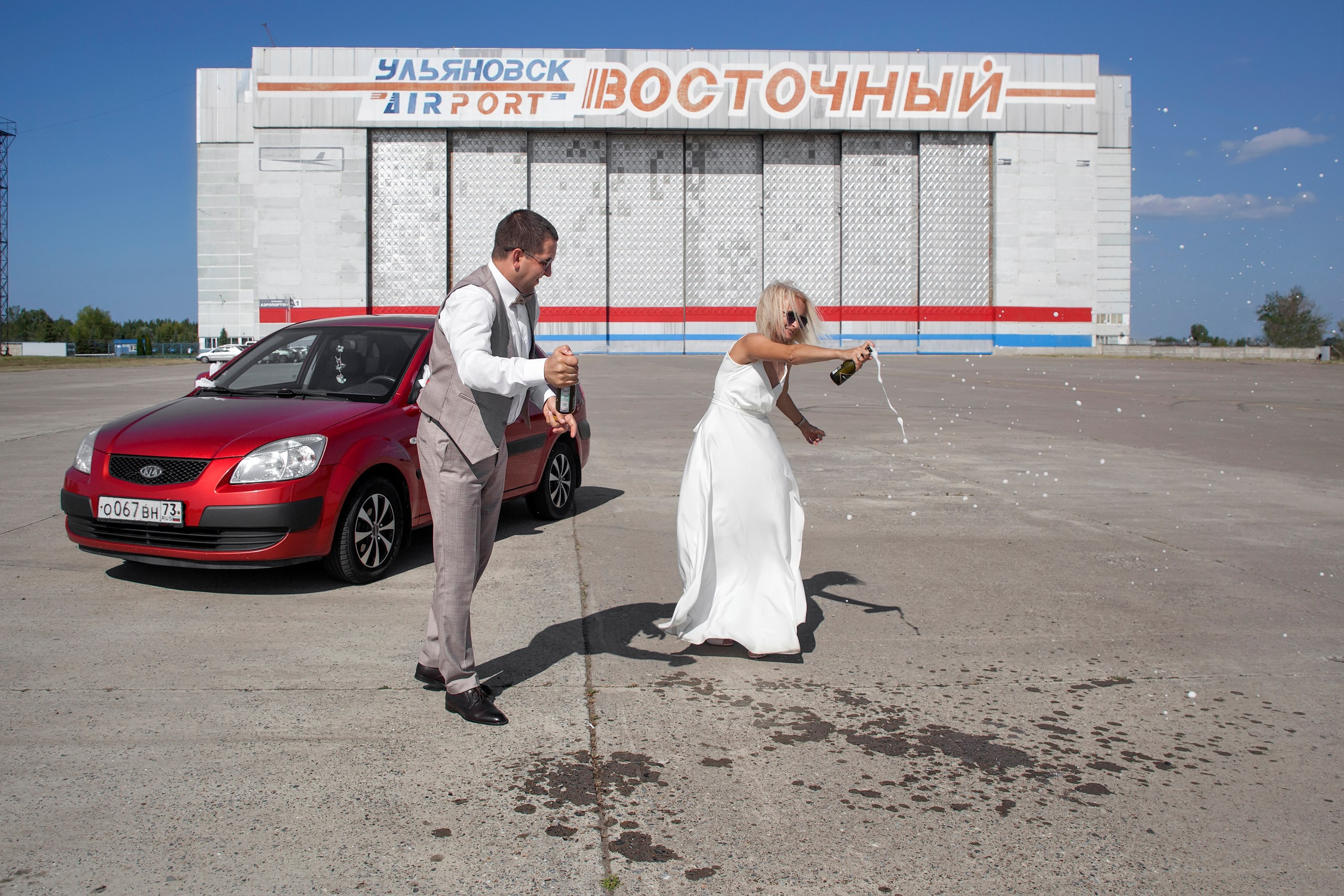 Жених с невестой обливаются шампанским, свадебная прогулка