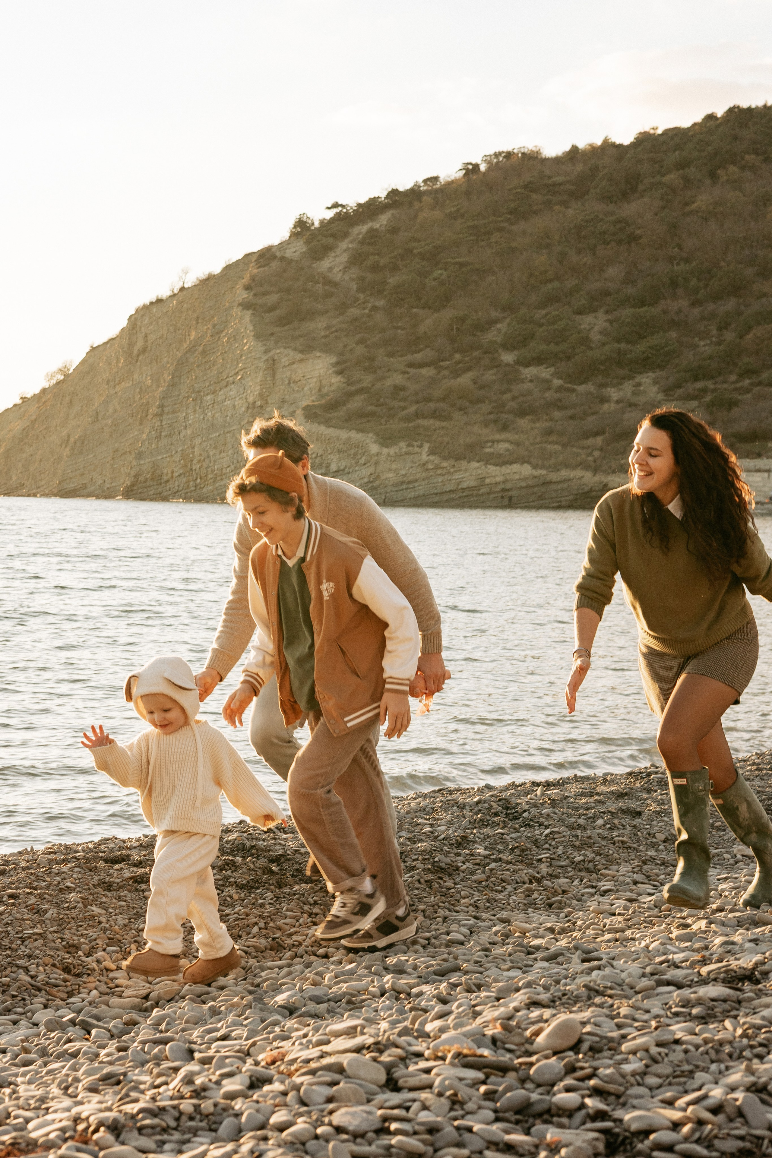 Единение с природой — Семья отдыхает на скалистом берегу с видом на бескрайнее море