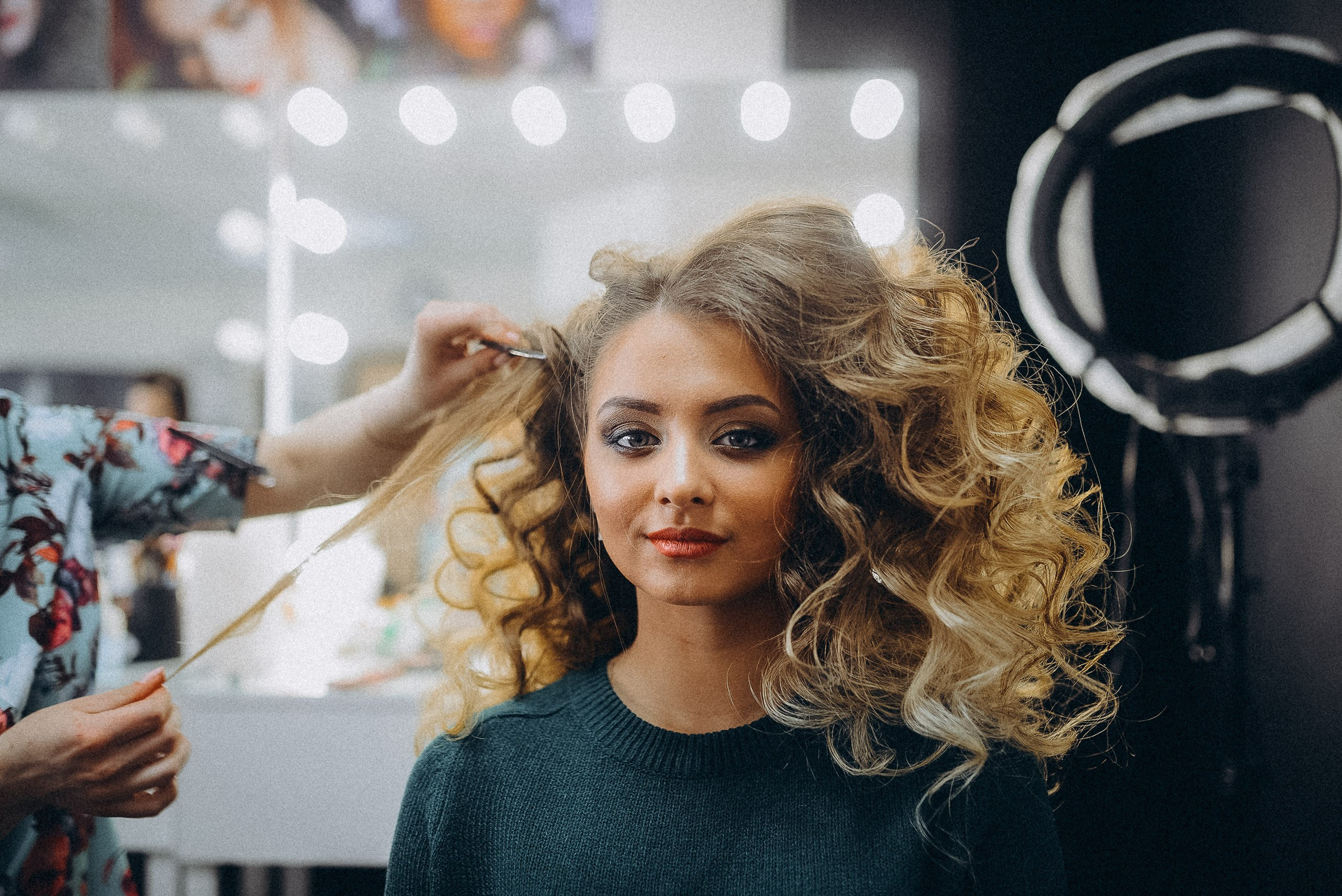 Процесс создания прически: стилист работает над образом конкурсантки за кулисами мероприятия