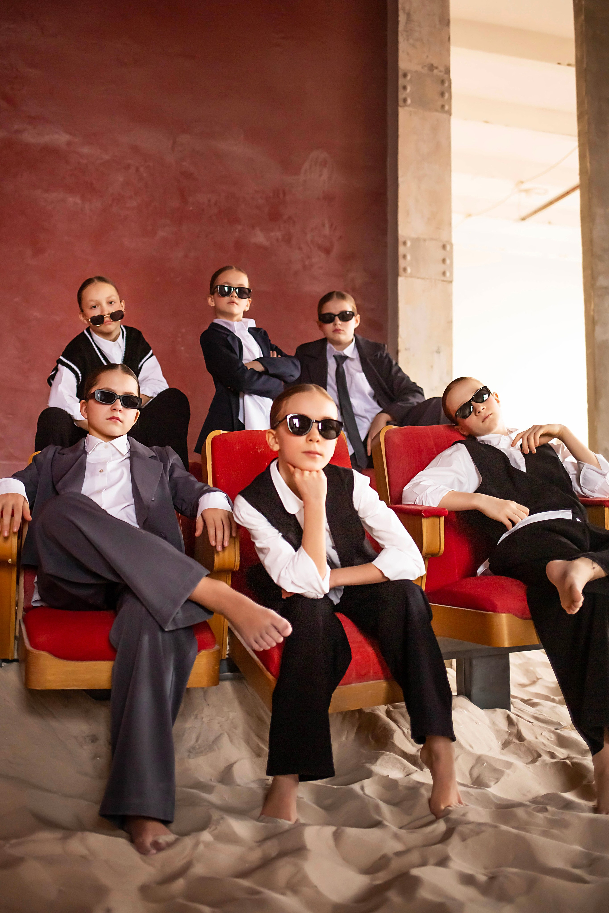 Постановочная фотосессия детского коллектива в солнечных очках на песке в фотостудии в СПБ