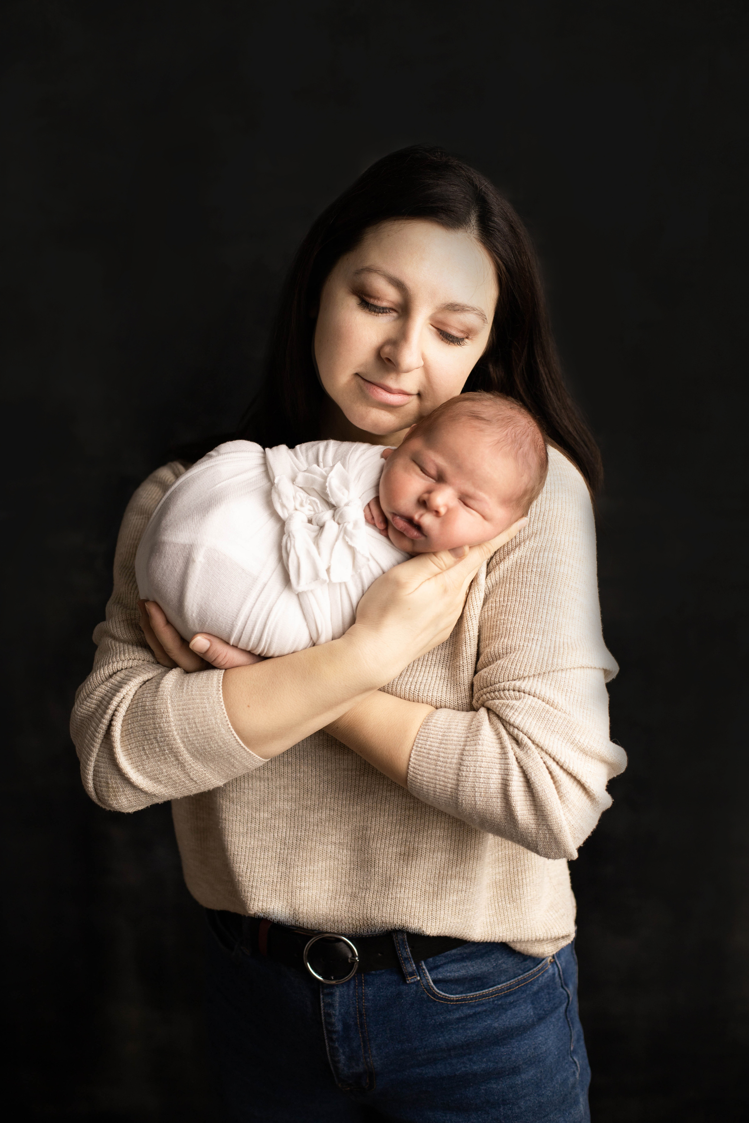 Мама с нежностью держит на руках своего новорожденного сына