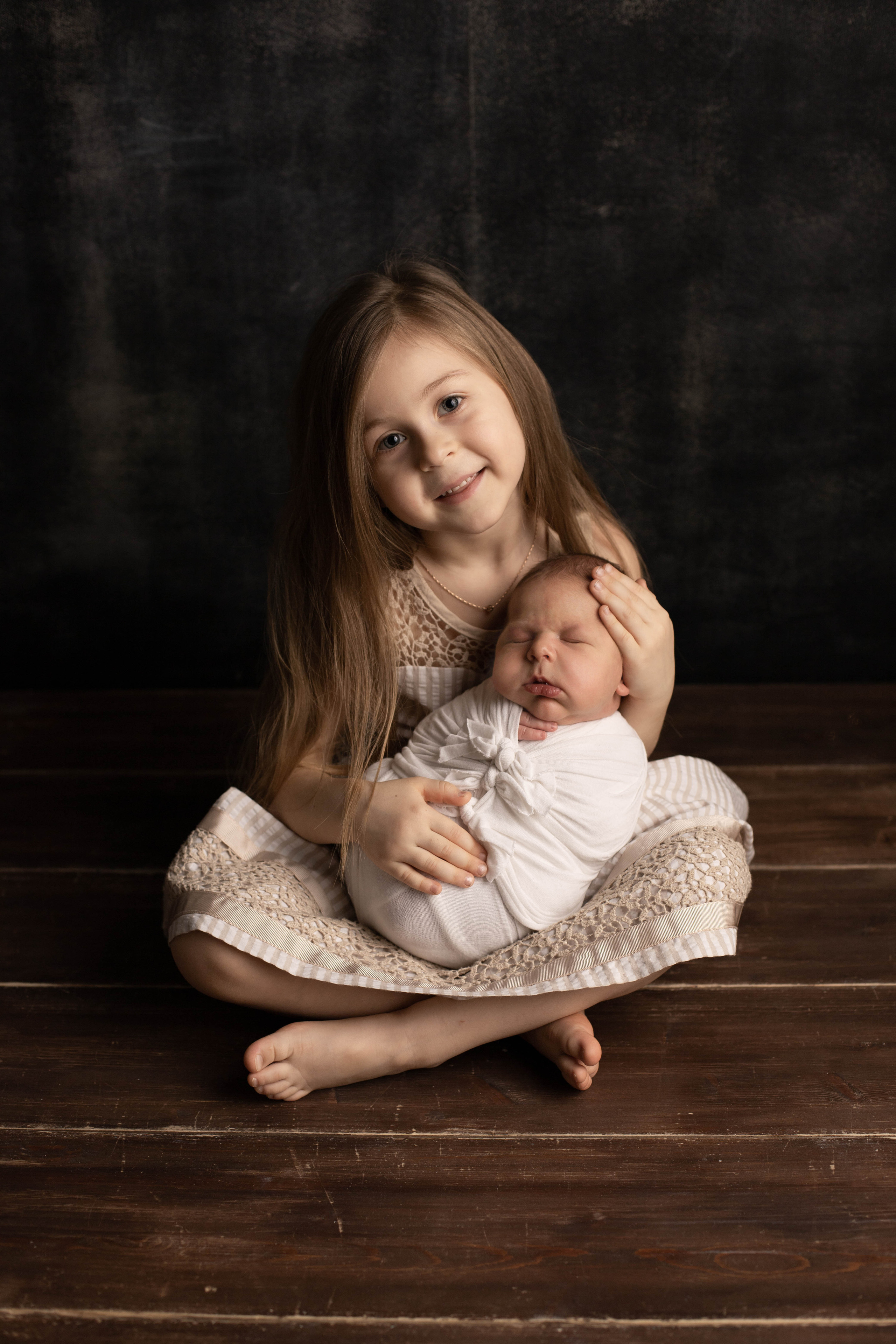 Фотография маленькой девочки сестрички с новорожденным братом на руках