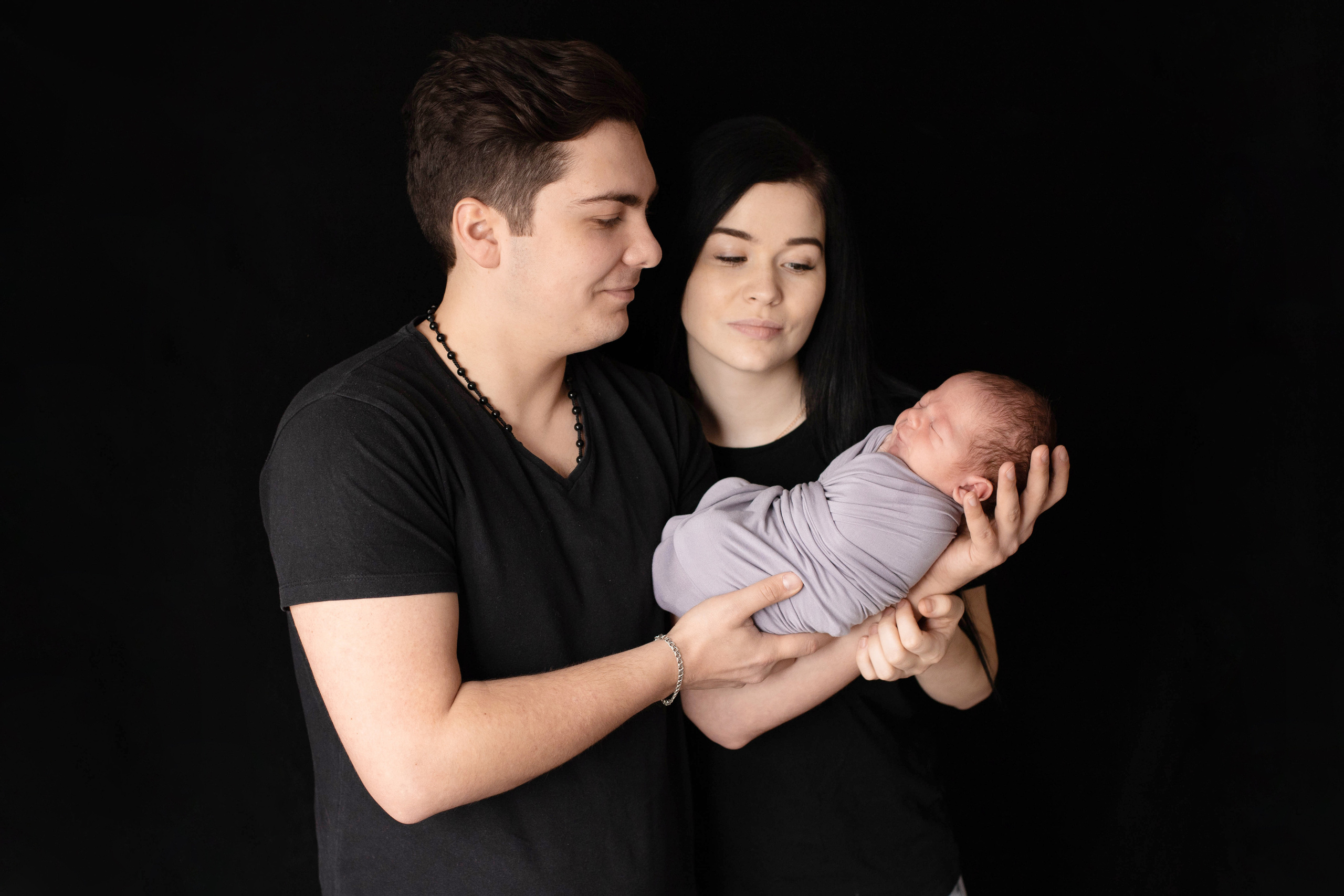 Фотография молодых родителей с новорожденным сыном на руках. 